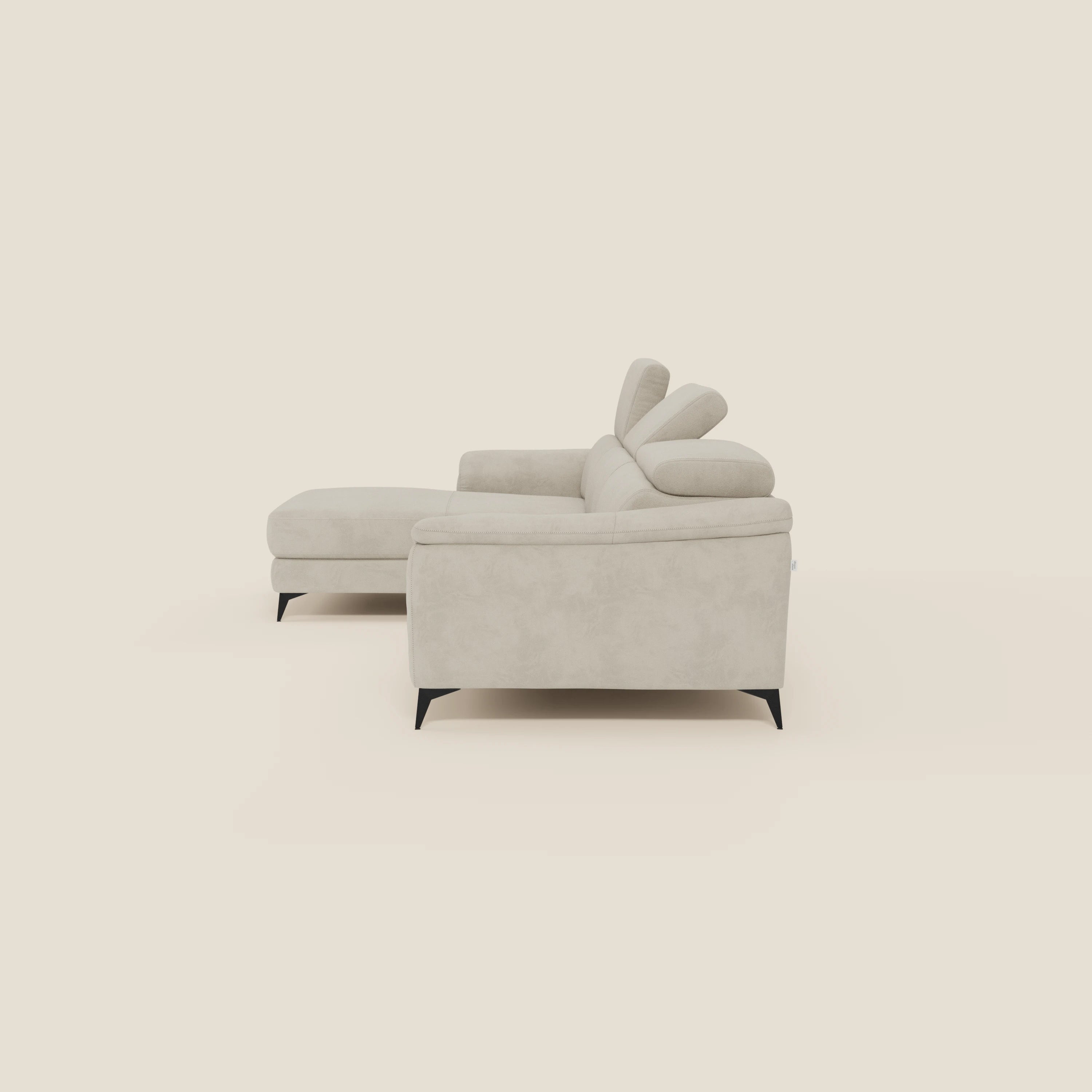 Arcos Divano con penisola di Divani.Store, in microfibra impermeabile panna T11, è caratterizzato da una chaise rivolta a sinistra, gambe alte, poggiatesta regolabili, braccioli dritti, cuscini in feltro e una moderna lavorazione italiana su uno sfondo color crema.