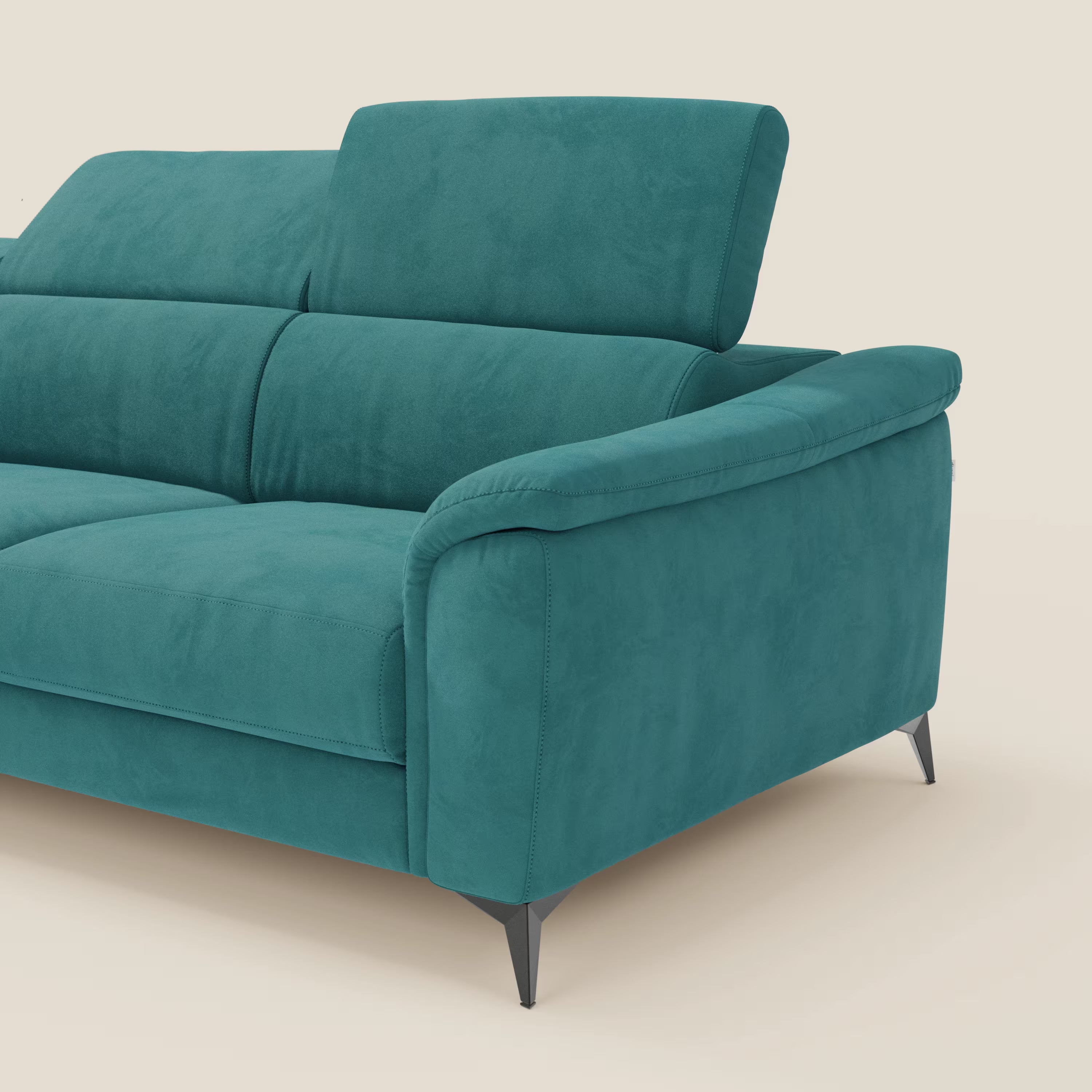 L'Arcos Divano con penisola di Divani.Store, presentato in microfibra impermeabile T11 petrolio, ha alte gambe nere e poggiatesta regolabili. È visibile solo il lato destro, su uno sfondo beige chiaro.