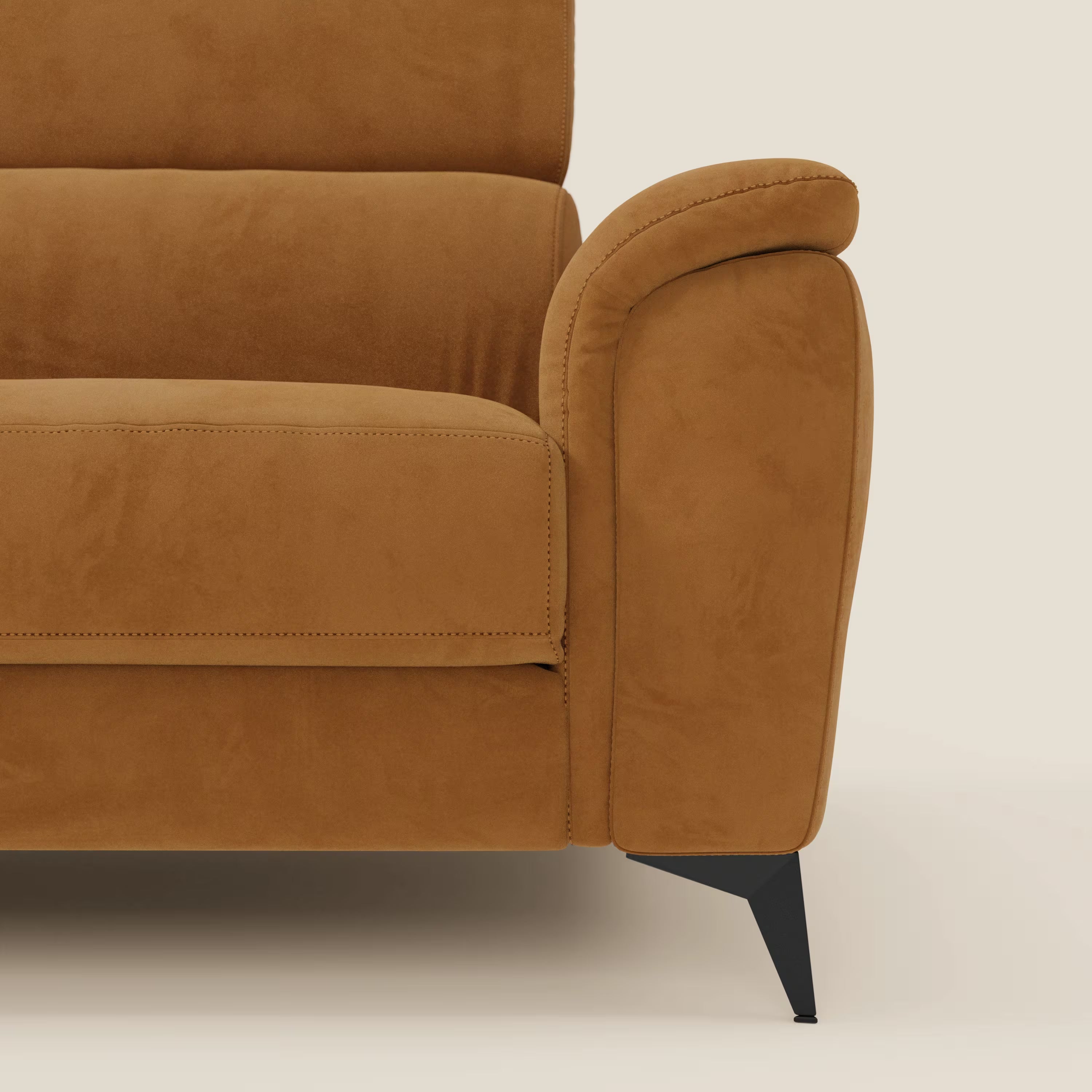 Primo piano del braccio destro e del cuscino di Arcos Divano 3 posti di Divani.Store in microfibra impermeabile T11 cuoio, caratterizzato da un bracciolo dolcemente curvo, una sottile gamba angolare in metallo nero e un'imbottitura soffice su uno sfondo beige chiaro.