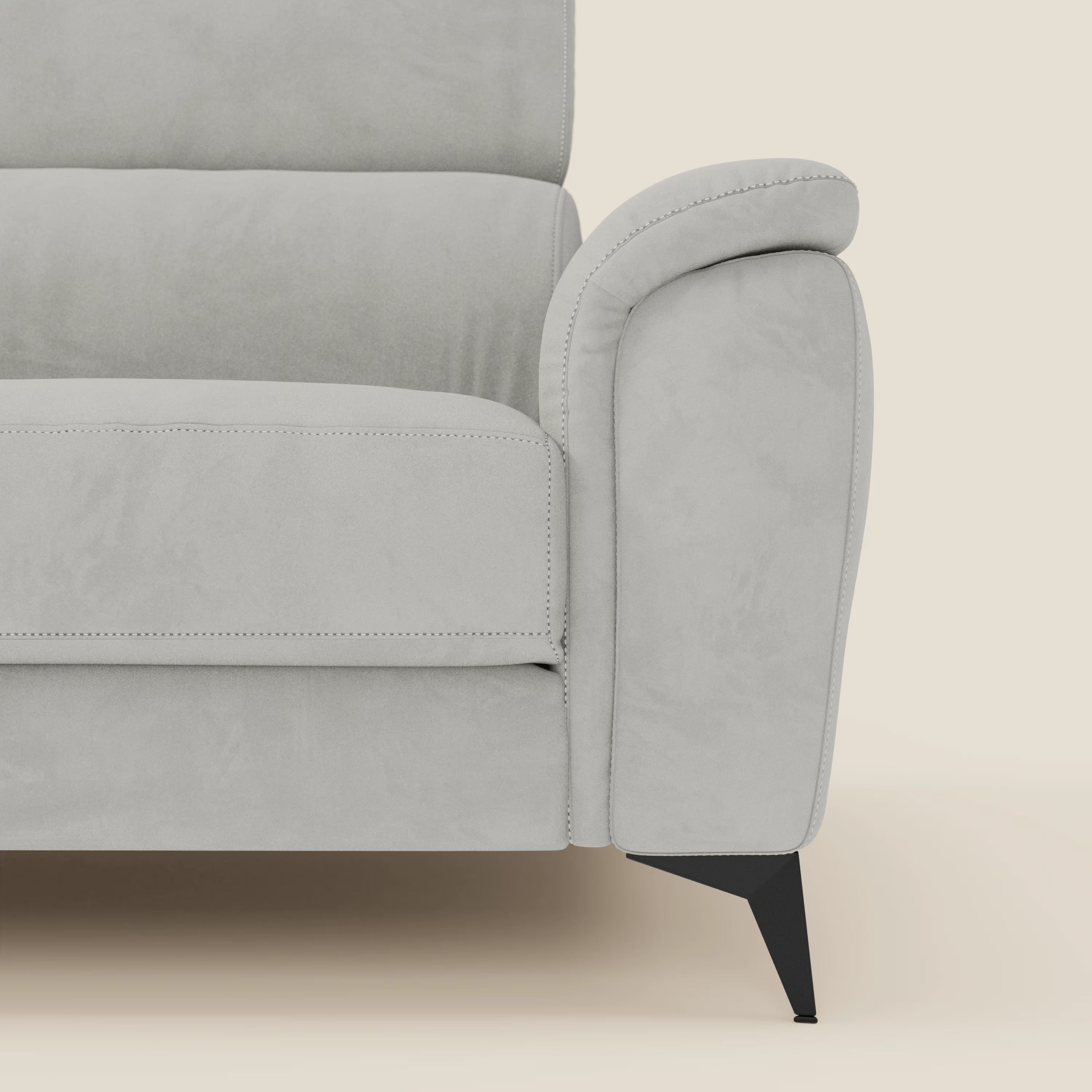 Un primo piano di Arcos Divano 3 posti di Divani.Store in microfibra impermeabile T11 grigio chiaro mostra il bracciolo sinistro, la seduta, lo schienale e la gamba alta angolata nera su uno sfondo bianco sporco che ne evidenzia le linee pulite e la sensazione di morbidezza.