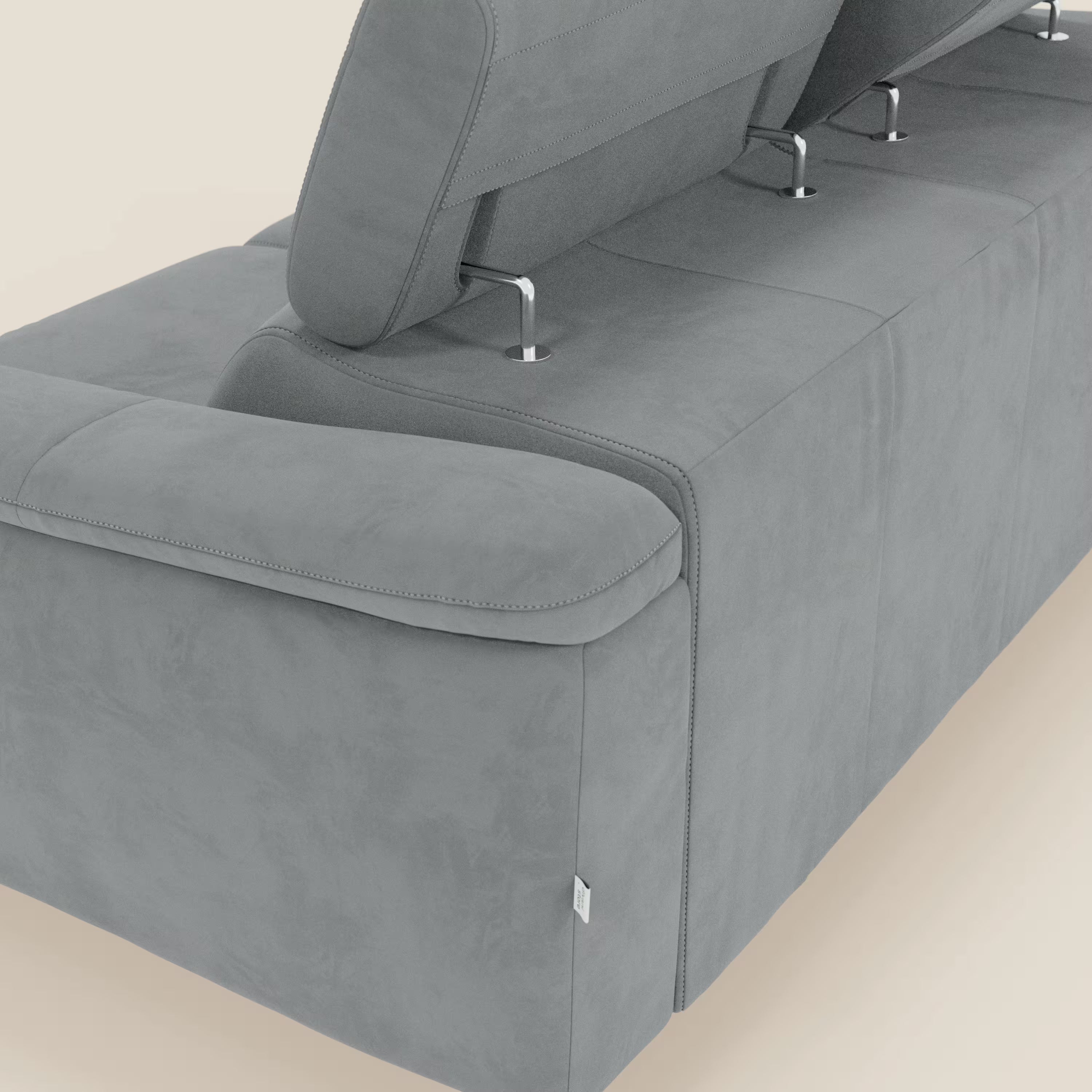 Un primo piano di Arcos Divano 3 posti di Divani.Store in microfibra impermeabile T11 grigio mette in evidenza il bracciolo, le cuciture dettagliate, i tre poggiatesta regolabili con supporti cromati e le gambe alte su uno sfondo chiaro.