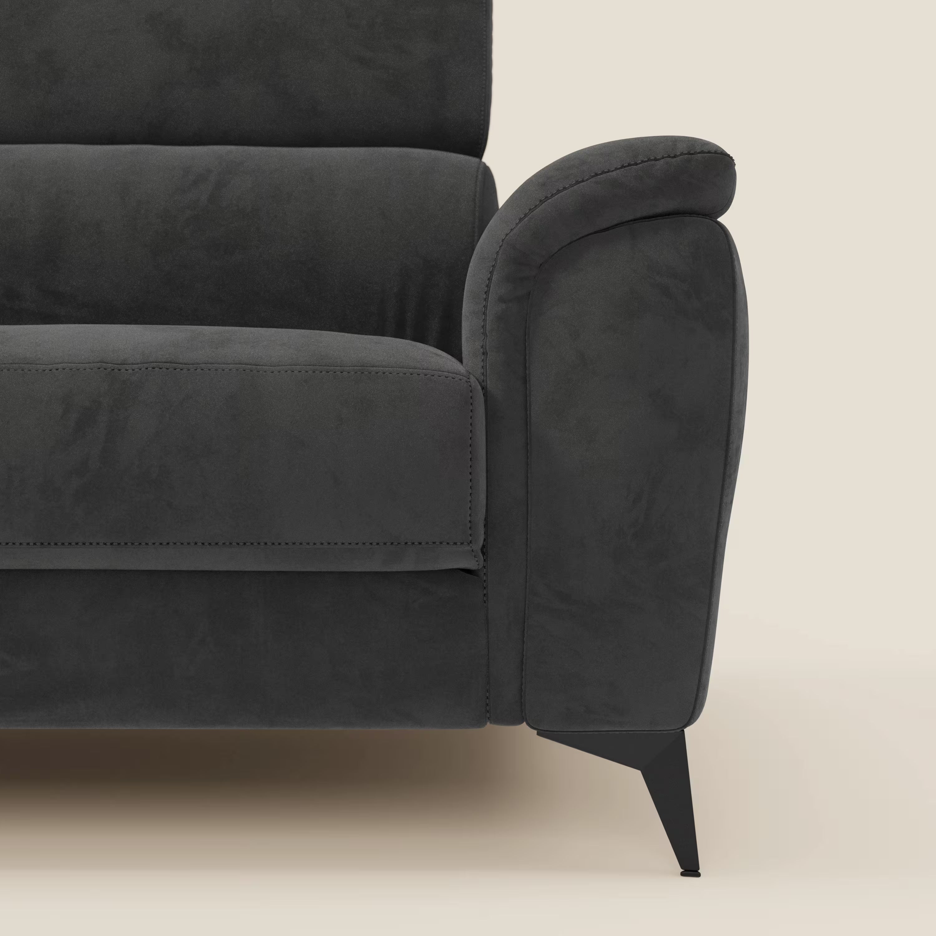 Primo piano di Arcos Divano 3 posti di Divani.Store in microfibra impermeabile T11 nero, con bracciolo arrotondato a destra, cuscini morbidi ed eleganti gambe alte in metallo nero su sfondo beige chiaro.