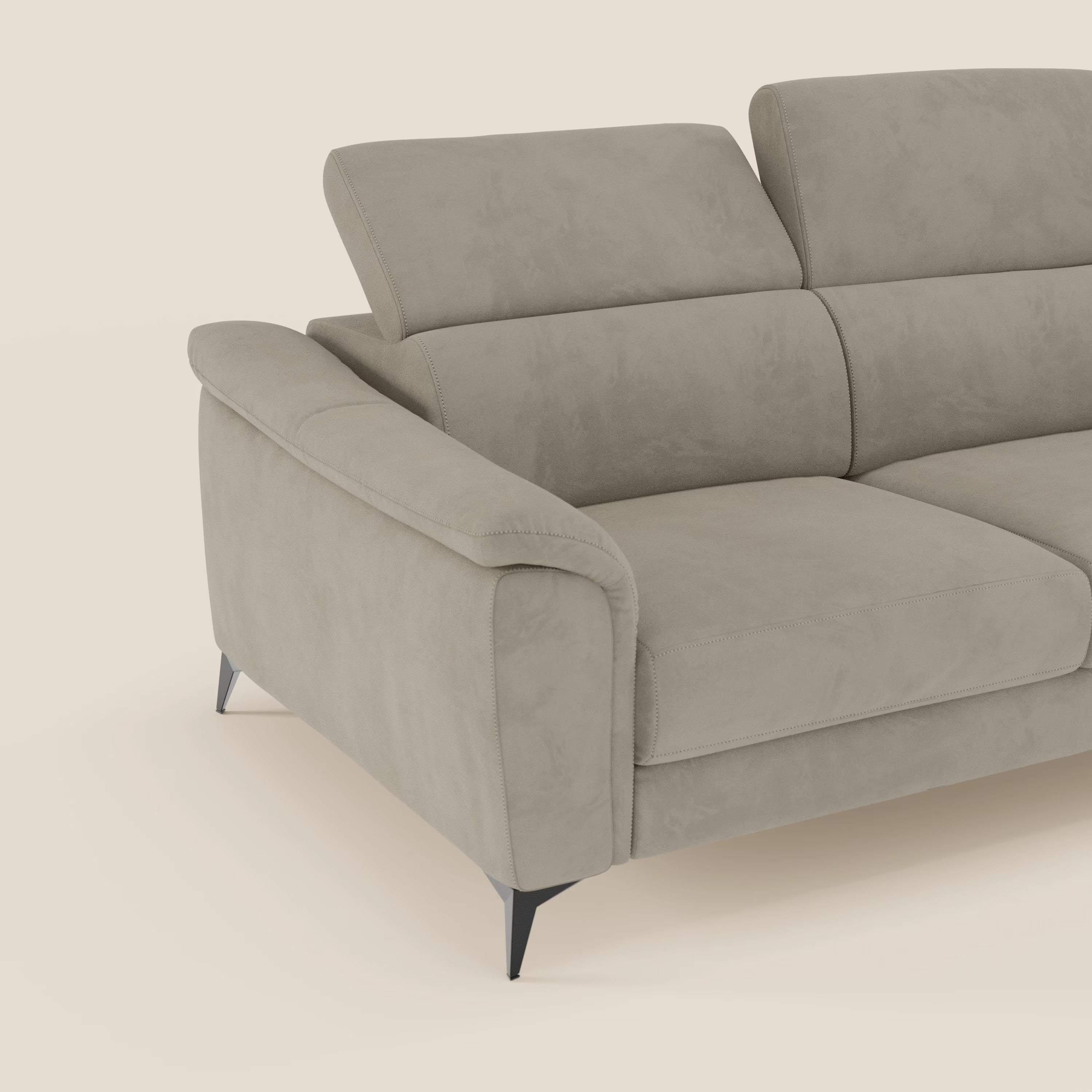 Arcos Divano 3 posti di Divani.Store è caratterizzato da alte gambe in metallo e poggiatesta reclinabili, rivestiti in microfibra impermeabile T11 taupe. I braccioli imbottiti e le linee pulite spiccano su uno sfondo bianco sporco.