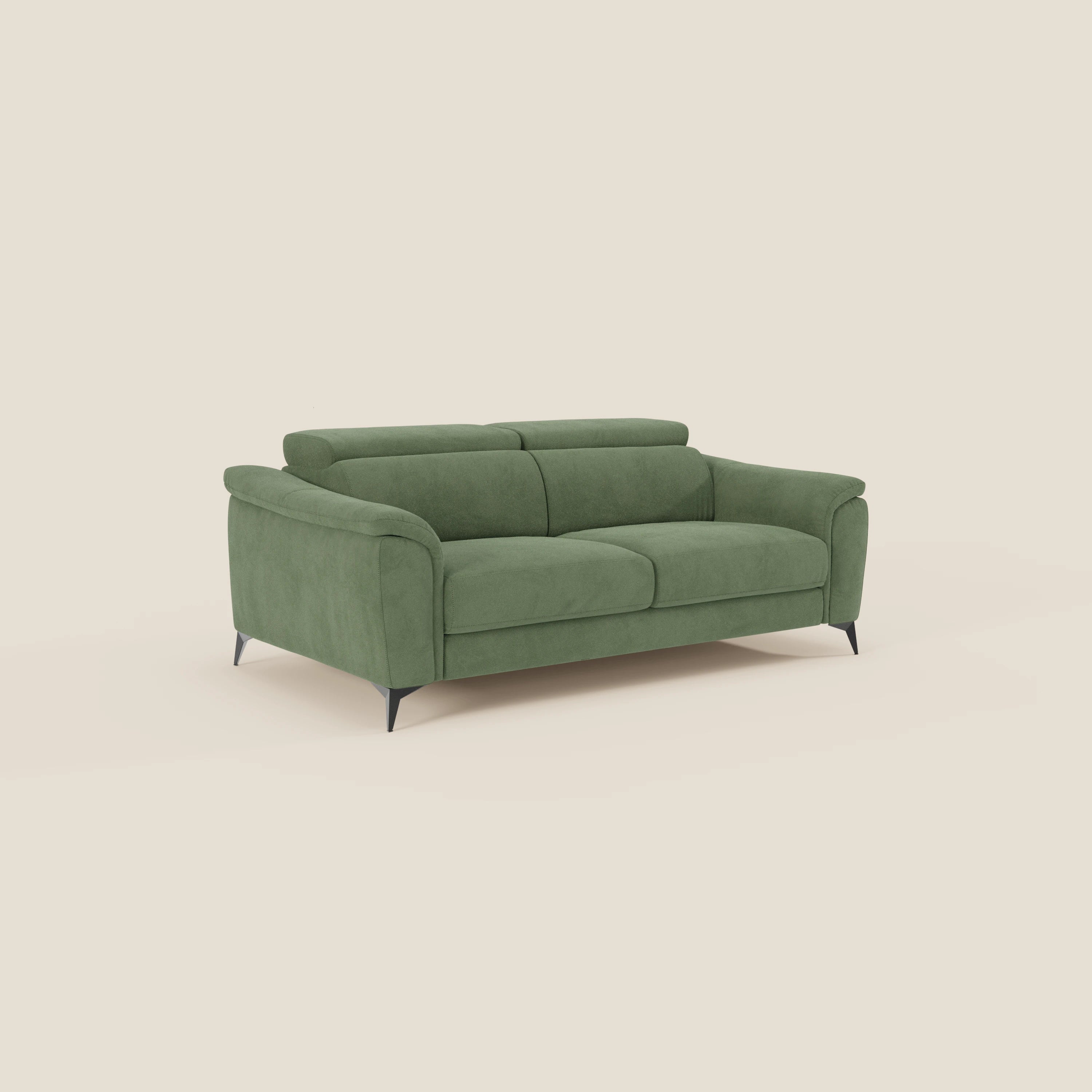 Arcos Divano 3 posti di Divani.Store è caratterizzato da gambe alte, poggiatesta reclinabili e rivestimento in microfibra impermeabile T11 verde salvia, qui raffigurato su uno sfondo bianco sporco.