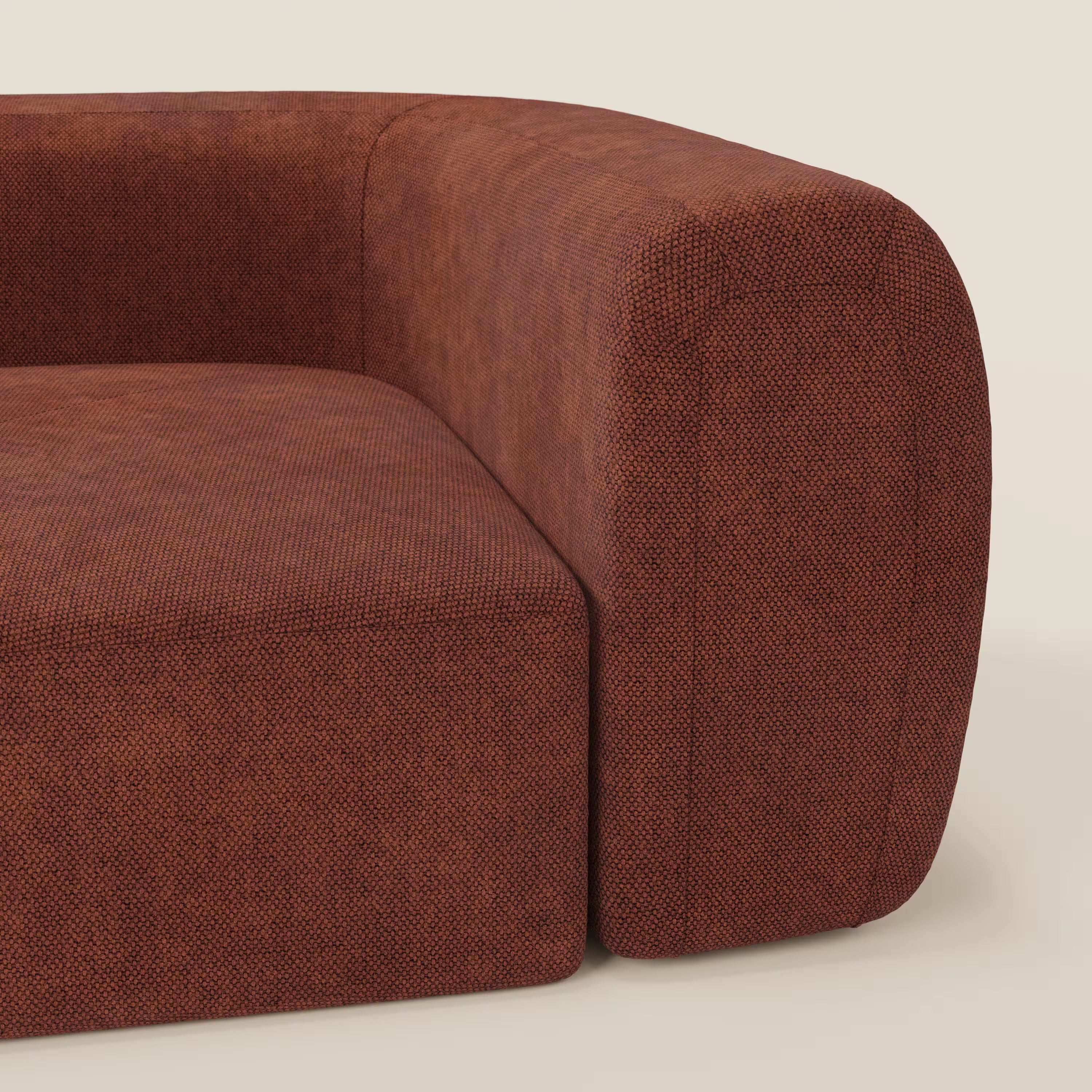 Primo piano del BonBon Modulo angolare - Divano modulare componibile GF edition di Divani.Store, caratterizzato da un rivestimento color ruggine con una sottile trama, bracciolo e cuscino spesso e curvo, bordi arrotondati e sfondo beige.