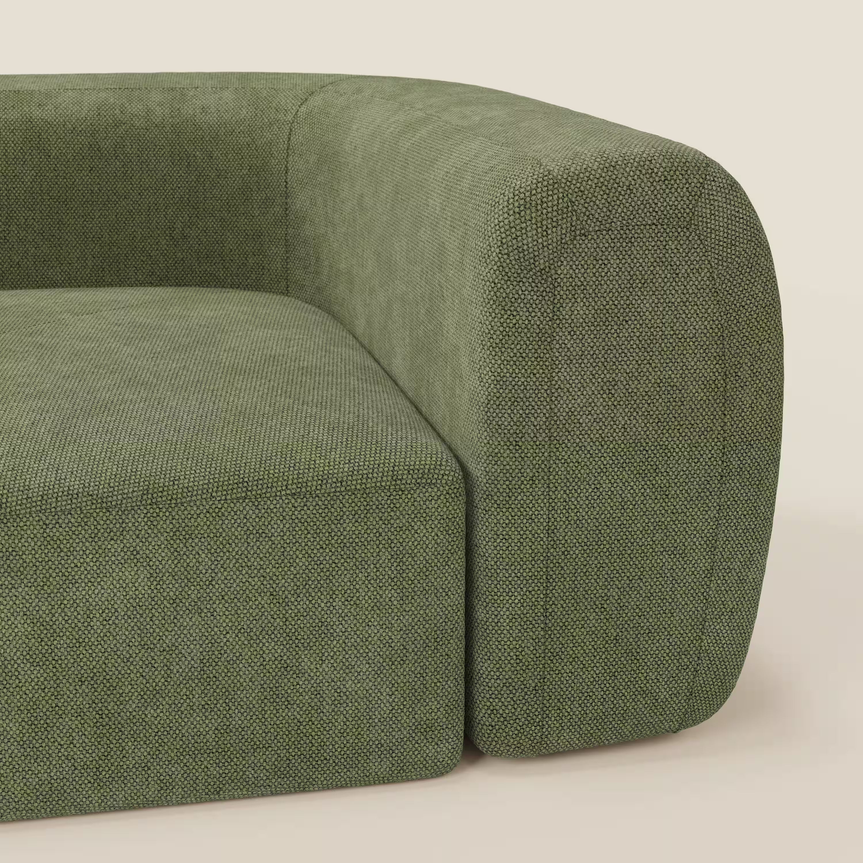 Primo piano del BonBon Modulo angolare - Divano componibile GF edition verde muschio di Divani.Store, un divano moderno di colore verde con bracciolo e schienale arrotondati, che mette in risalto il suo rivestimento strutturato su uno sfondo chiaro.