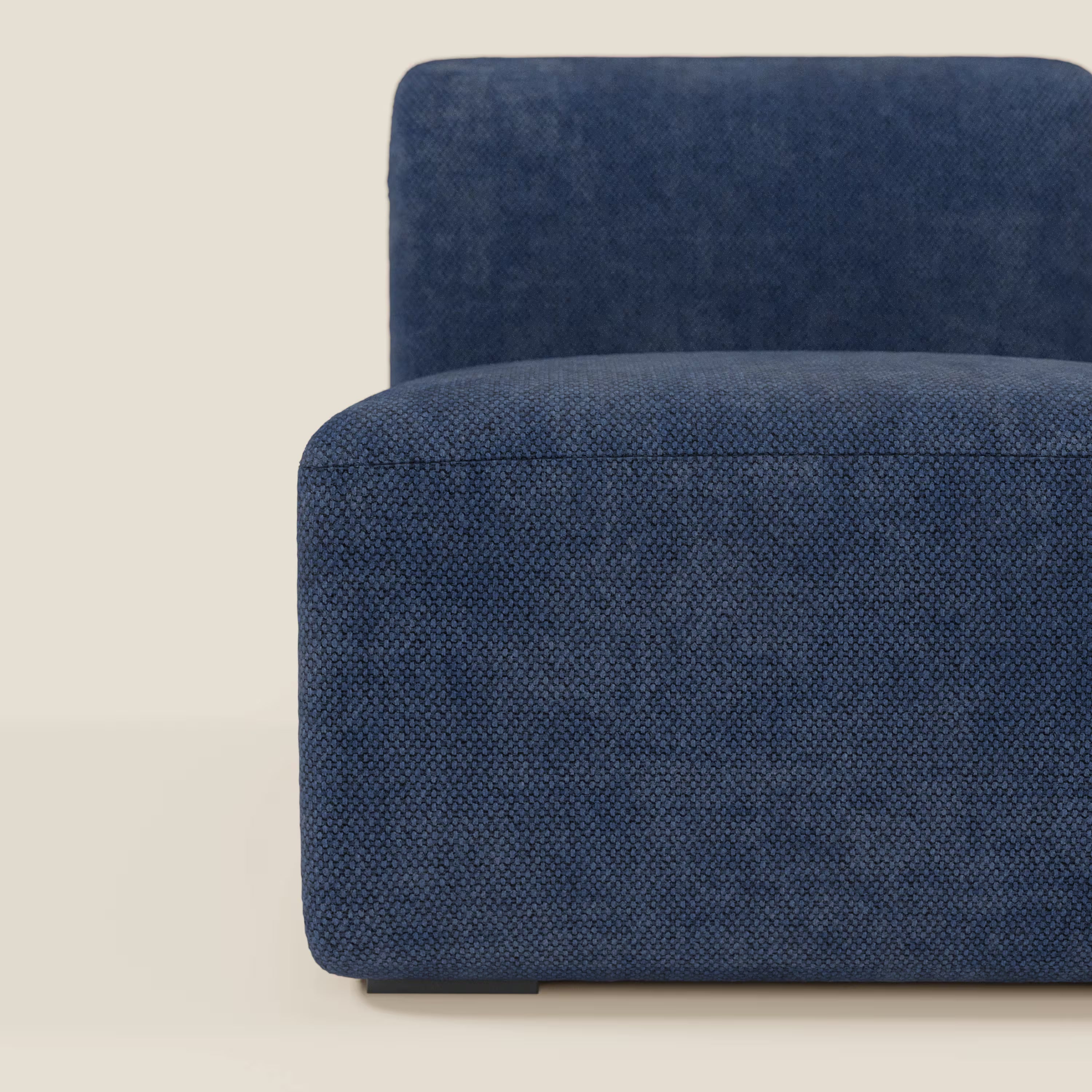 Divani.Store BonBon modulo centrale 70 cm - Grande Fratello edition blu navy è una sedia moderna senza braccioli dalla forma bassa e squadrata, realizzata in tessuto testurizzato blu navy. Solo la metà sinistra, con seduta, schienale e bordo curvo, appare su uno sfondo bianco sporco.