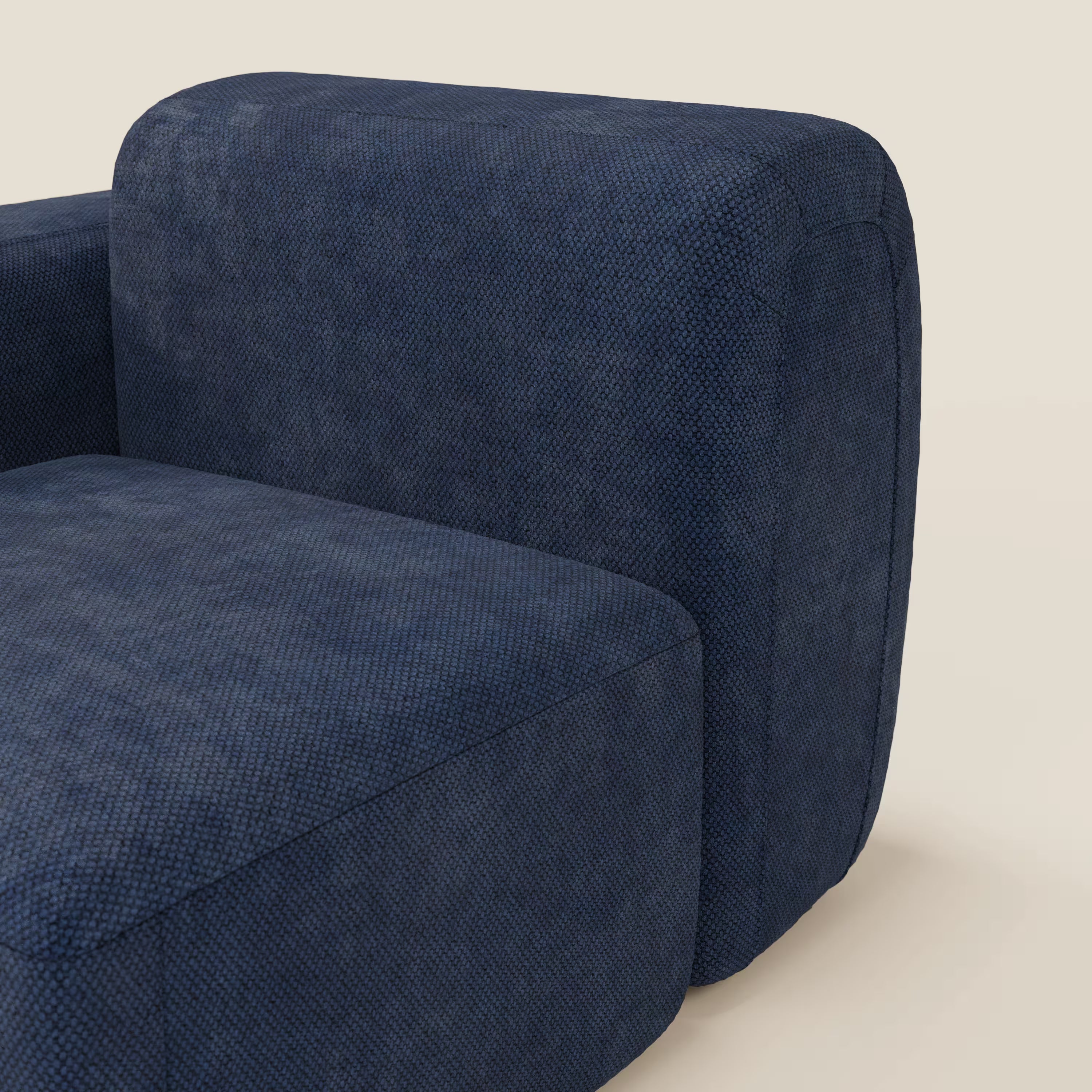 Primo piano del modulo BonBon terminale 105 cm sinistro o destro - Grande Fratello edition blu navy di Divani.Store, caratterizzato da bracciolo e seduta arrotondati con rivestimento blu testurizzato, Made in Italy, su sfondo beige tinta unita.