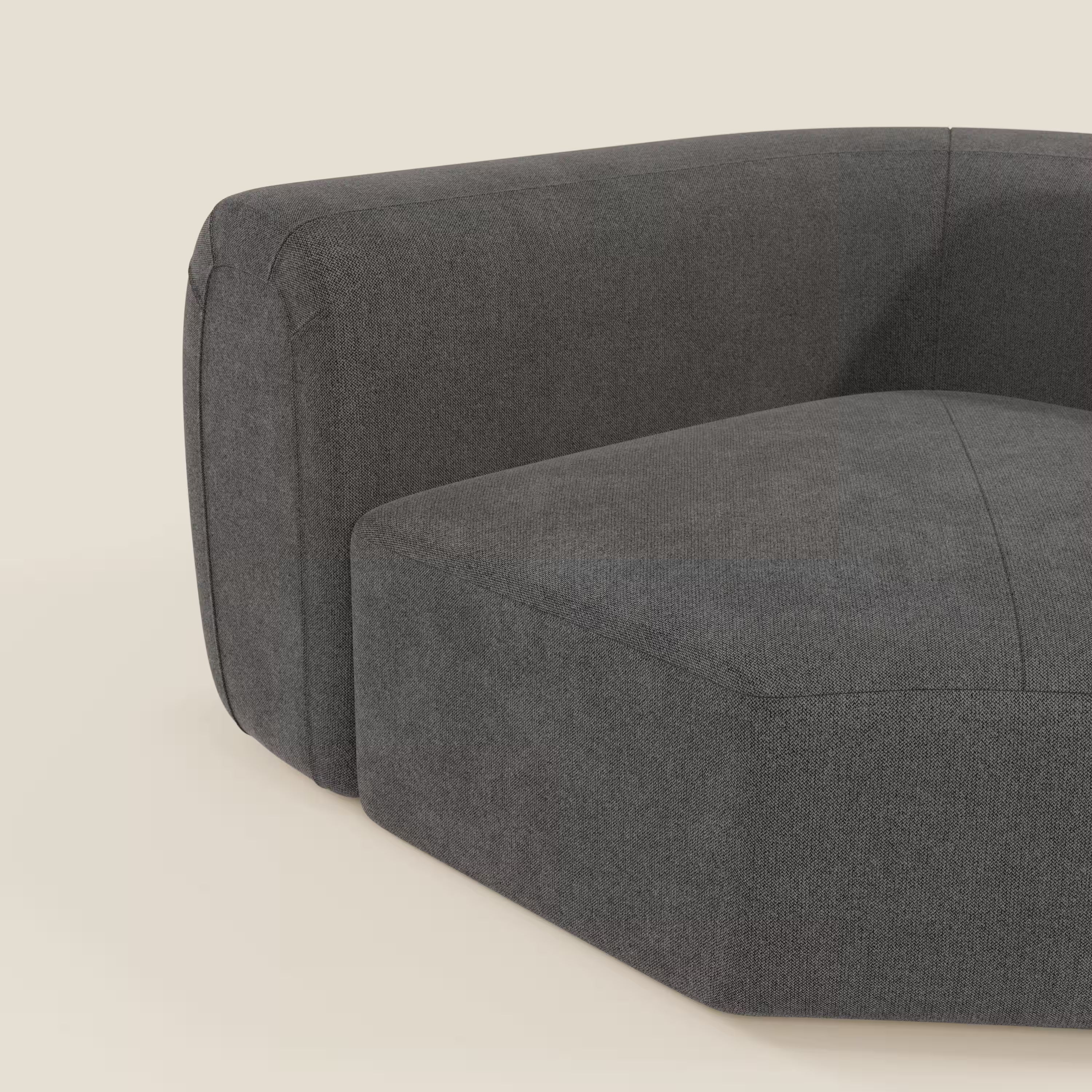 Primo piano di Bonbon Modulo angolare di Divani.Store, un moderno divano componibile in tessuto antracite T23 antimacchia, con ampi braccioli e seduta spessa, inserito in un semplice sfondo beige chiaro che ne evidenzia le linee minimaliste.