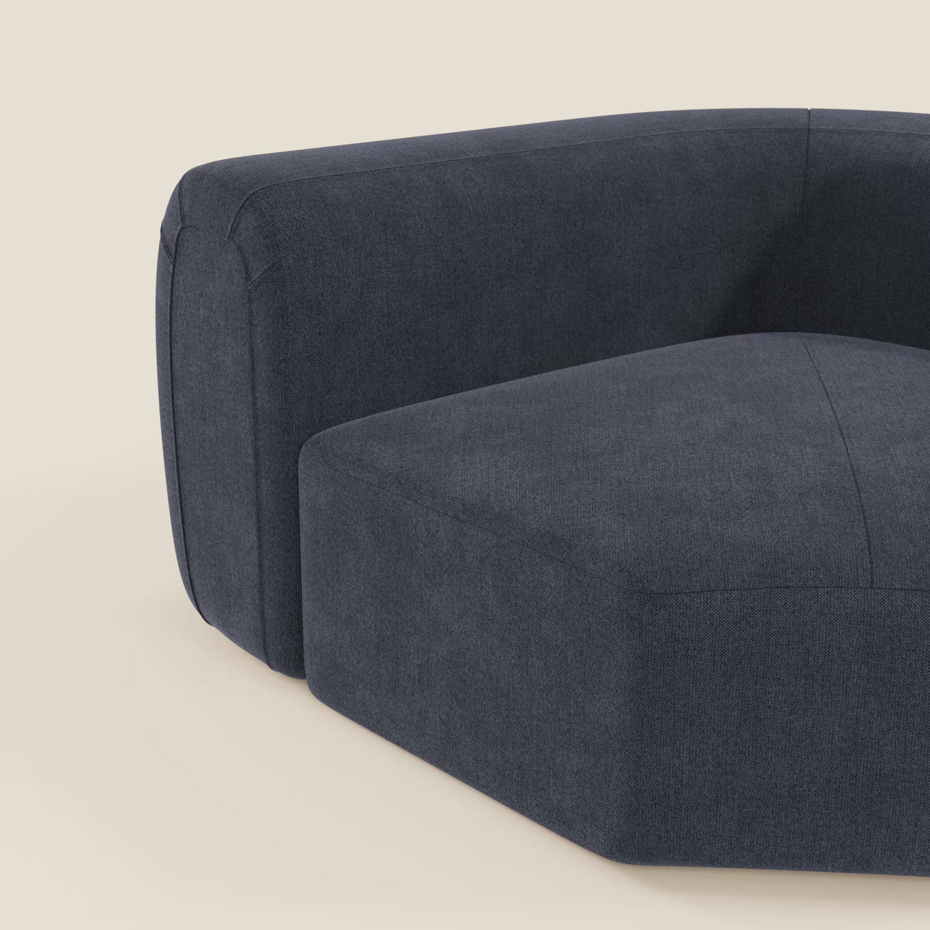 Primo piano di Bonbon Modulo angolare di Divani.Store, un moderno divano componibile in ardesia blu tessuto smacchiabile T23, che mostra linee morbide e pulite e una morbida imbottitura su uno sfondo bianco sporco.
