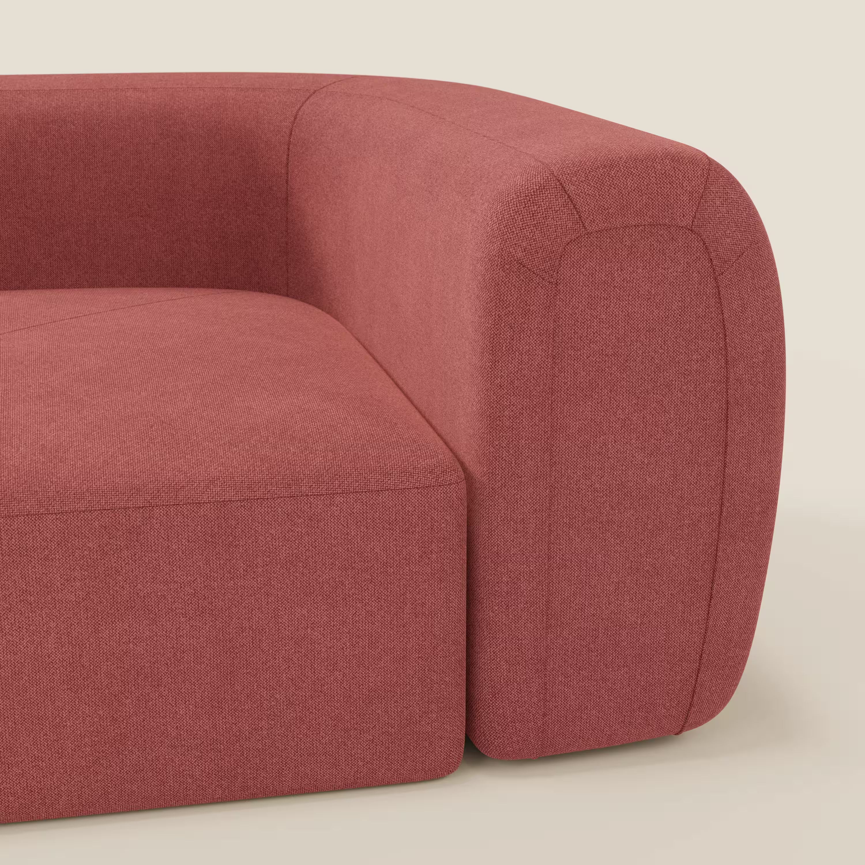 Primo piano di Bonbon Modulo angolare di Divani.Store, un moderno divano componibile in tessuto antimacchia T23 rosso ciliegia, caratterizzato da morbidi bordi arrotondati e da uno spesso bracciolo imbottito. Lo sfondo beige ne sottolinea il design contemporaneo.