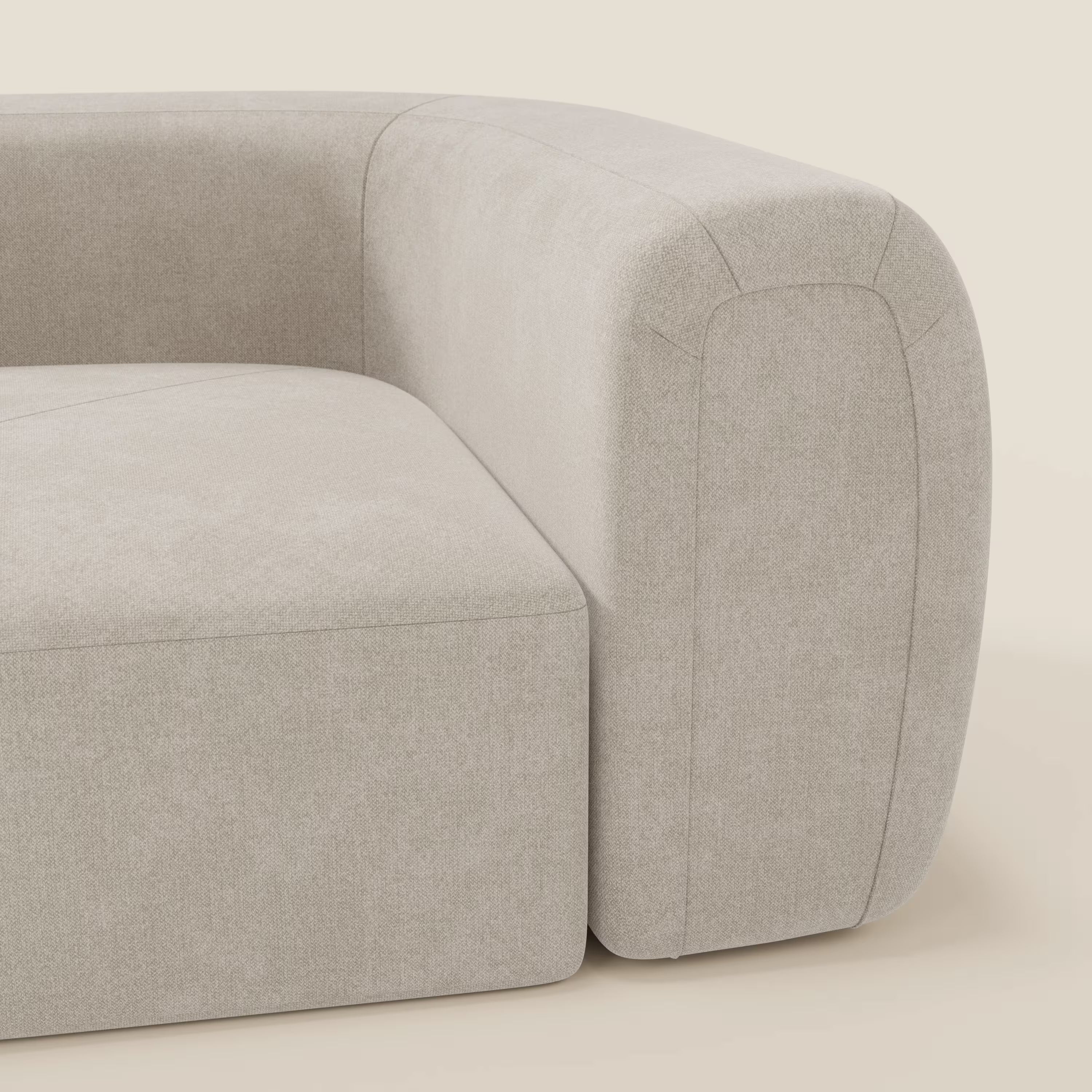 Un primo piano del Bonbon Modulo angolare di Divani.Store mostra il tessuto liscio antimacchia Panna T23 e le linee curve. Minimalista e moderno, questo divano modulare si staglia su uno sfondo chiaro per un'atmosfera contemporanea.