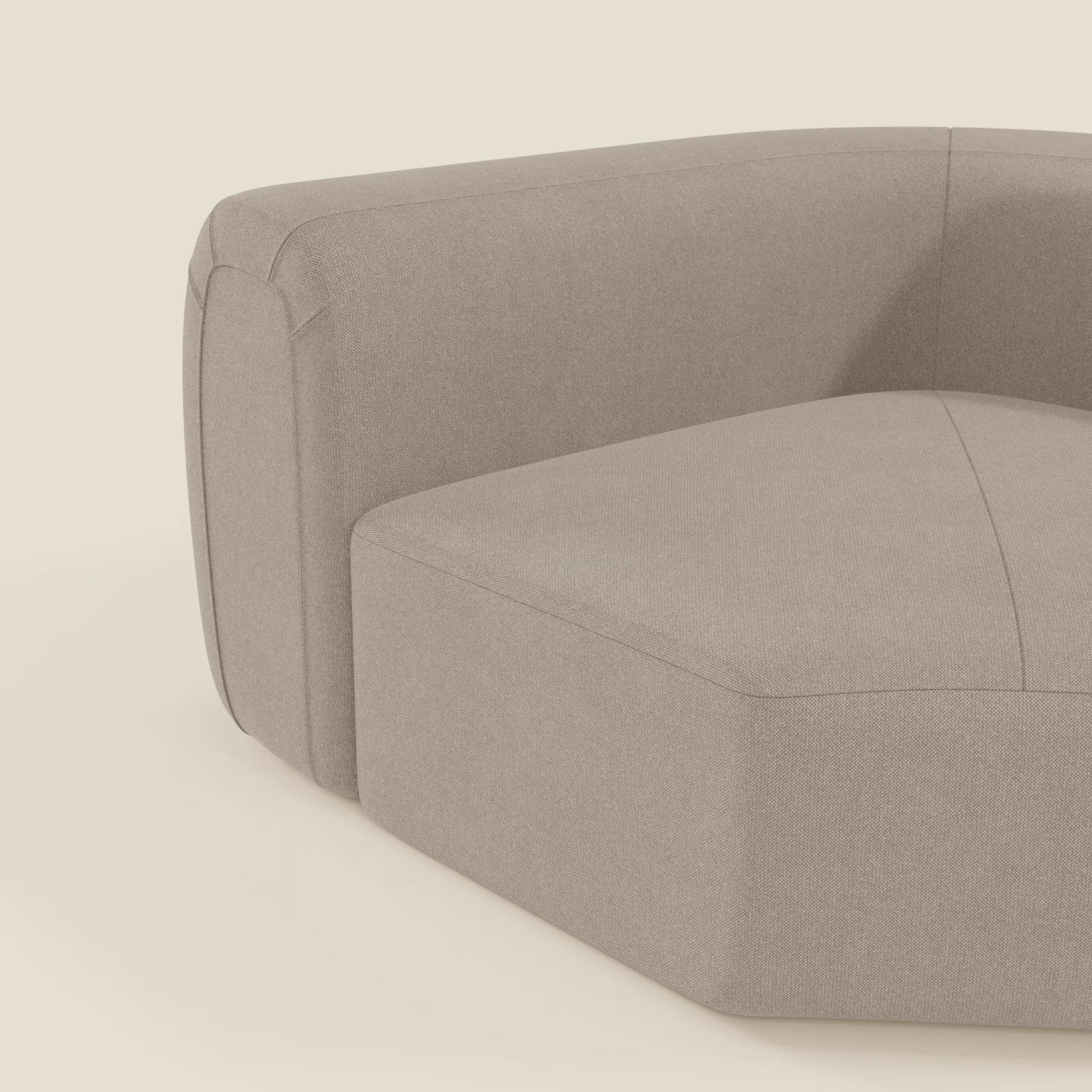 Il Bonbon Modulo angolare di Divani.Store, un divano componibile moderno in tessuto smacchiabile T23 tortora, spicca su sfondo chiaro con bracciolo ampio, linee pulite e cuciture evidenti per uno stile minimalista contemporaneo.