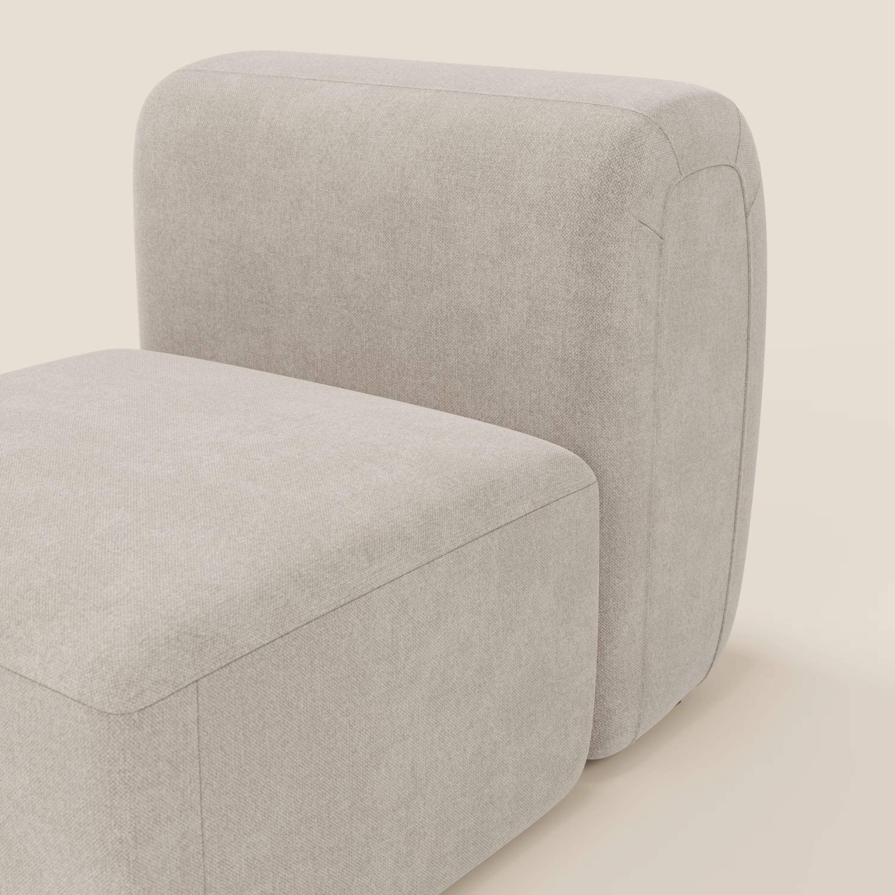 Un primo piano di BonBon modulo centrale 70 cm di Divani.Store, un'elegante sedia senza braccioli rivestita in tessuto antimacchia Panna T23 con bordi morbidi e cuciture minime, su uno sfondo semplice.