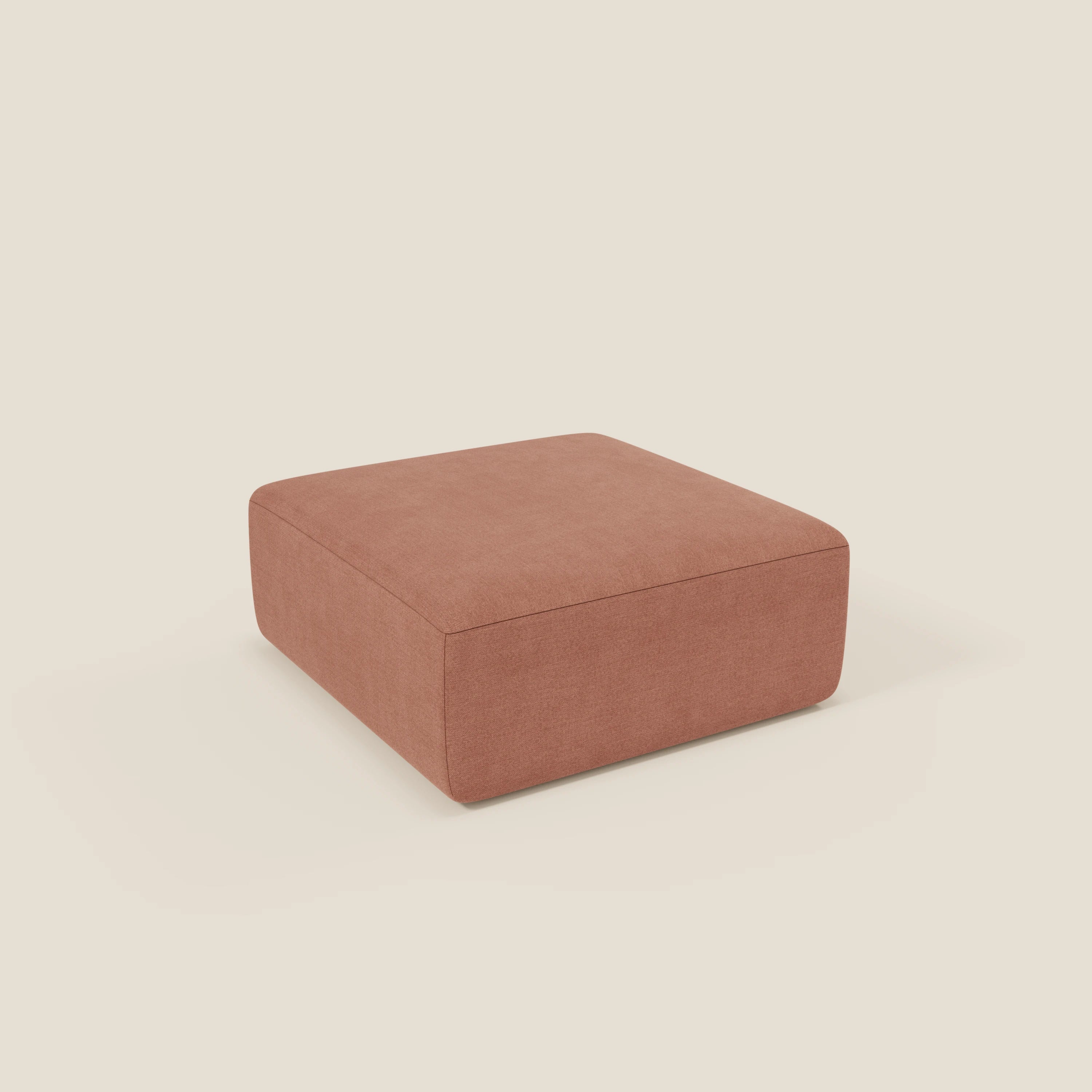 Il pouf BonBon di Divani.Store, una seduta modulare in due dimensioni con tessuto pesca antimacchia T23, poggia su uno sfondo bianco e unisce stile moderno e comfort.