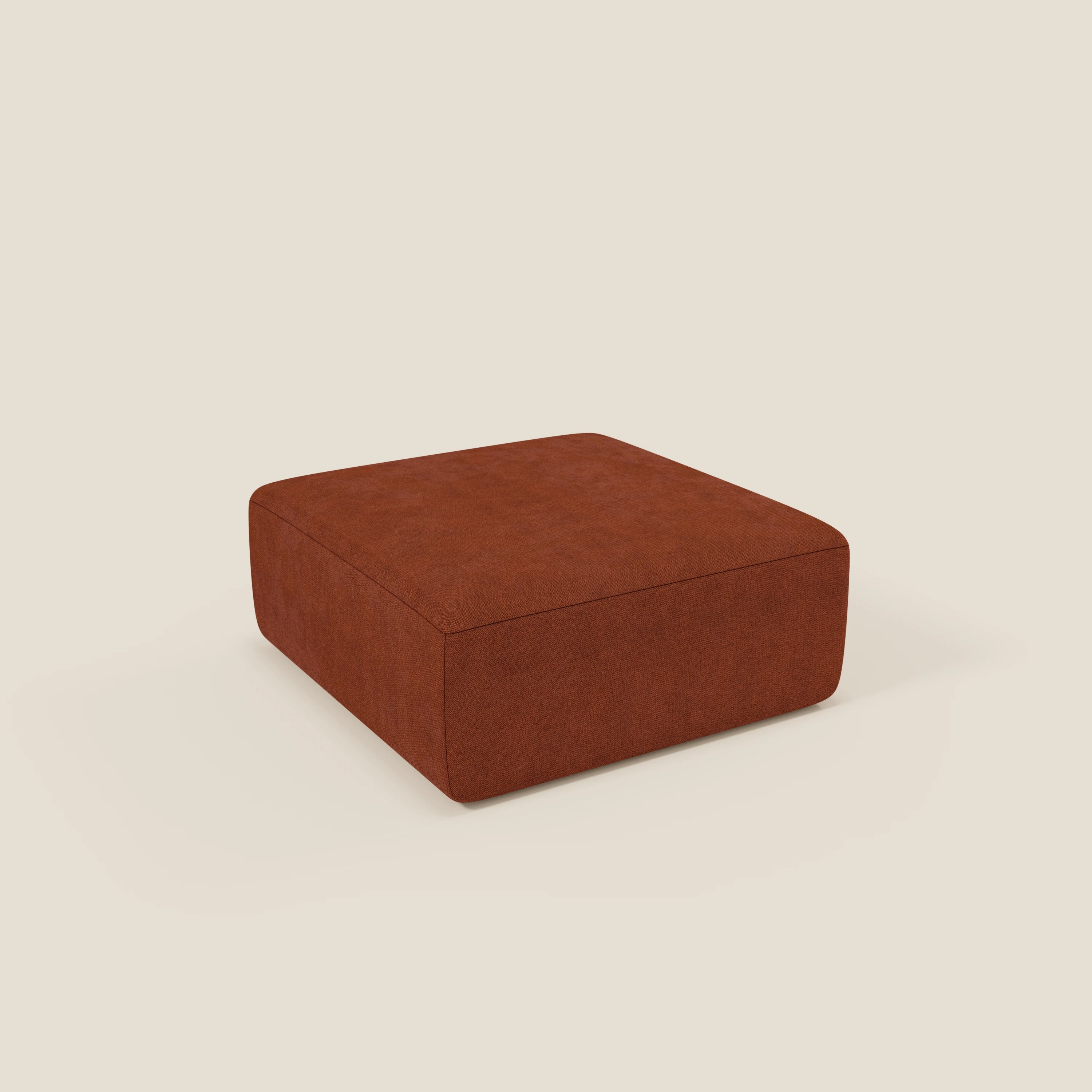 Il pouf divano modulare BonBon di Divani.Store, presentato in tessuto smacchiabile T23 ruggine, è caratterizzato da una forma quadrata, da un design minimalista con linee pulite, senza gambe a vista, e da un fondo beige chiaro.