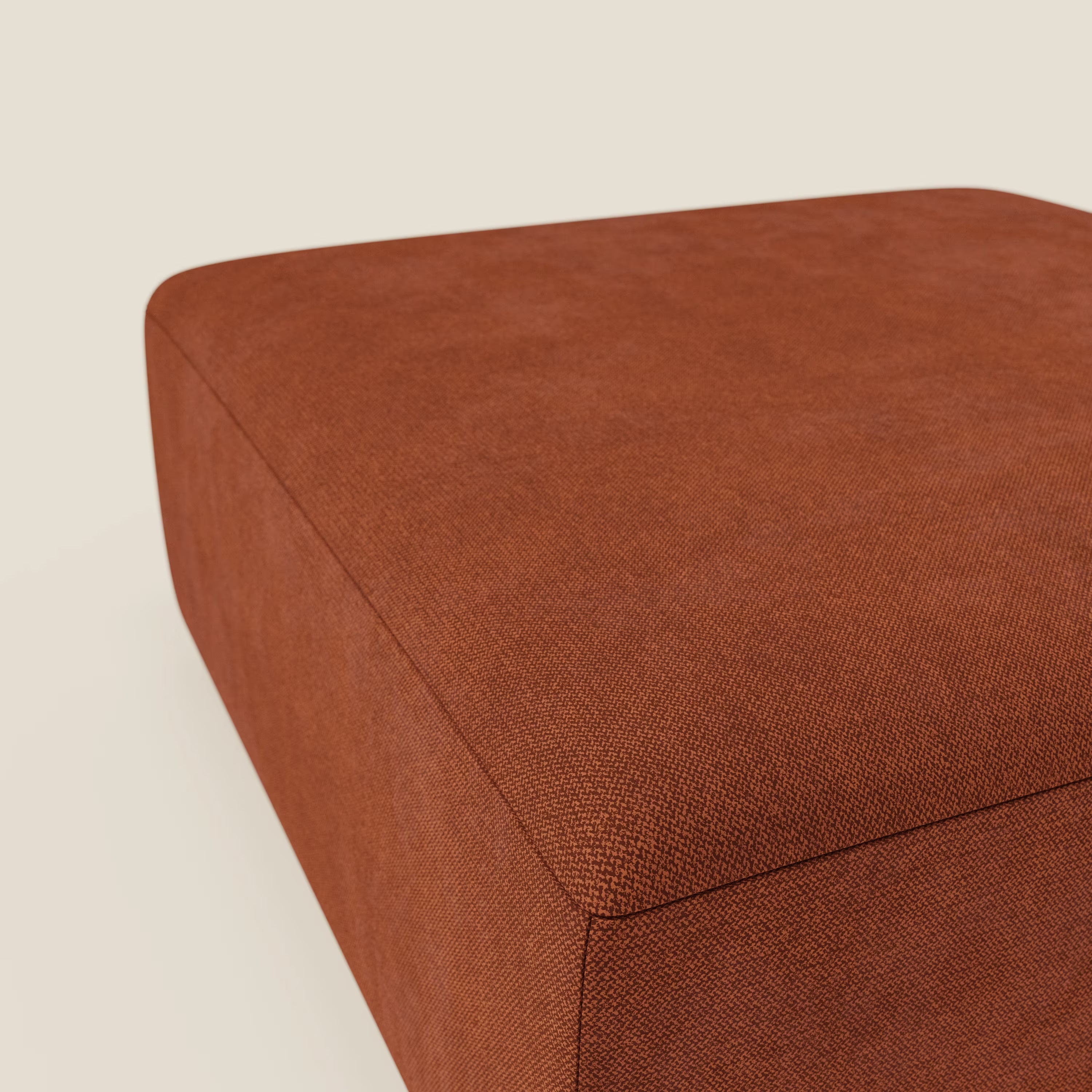 Un primo piano del pouf divano modulare BonBon di Divani.Store, presentato in formato grande con tessuto antimacchia T23 ruggine. Il ricco color ruggine e il design minimalista del pouf rettangolare spiccano su uno sfondo chiaro.