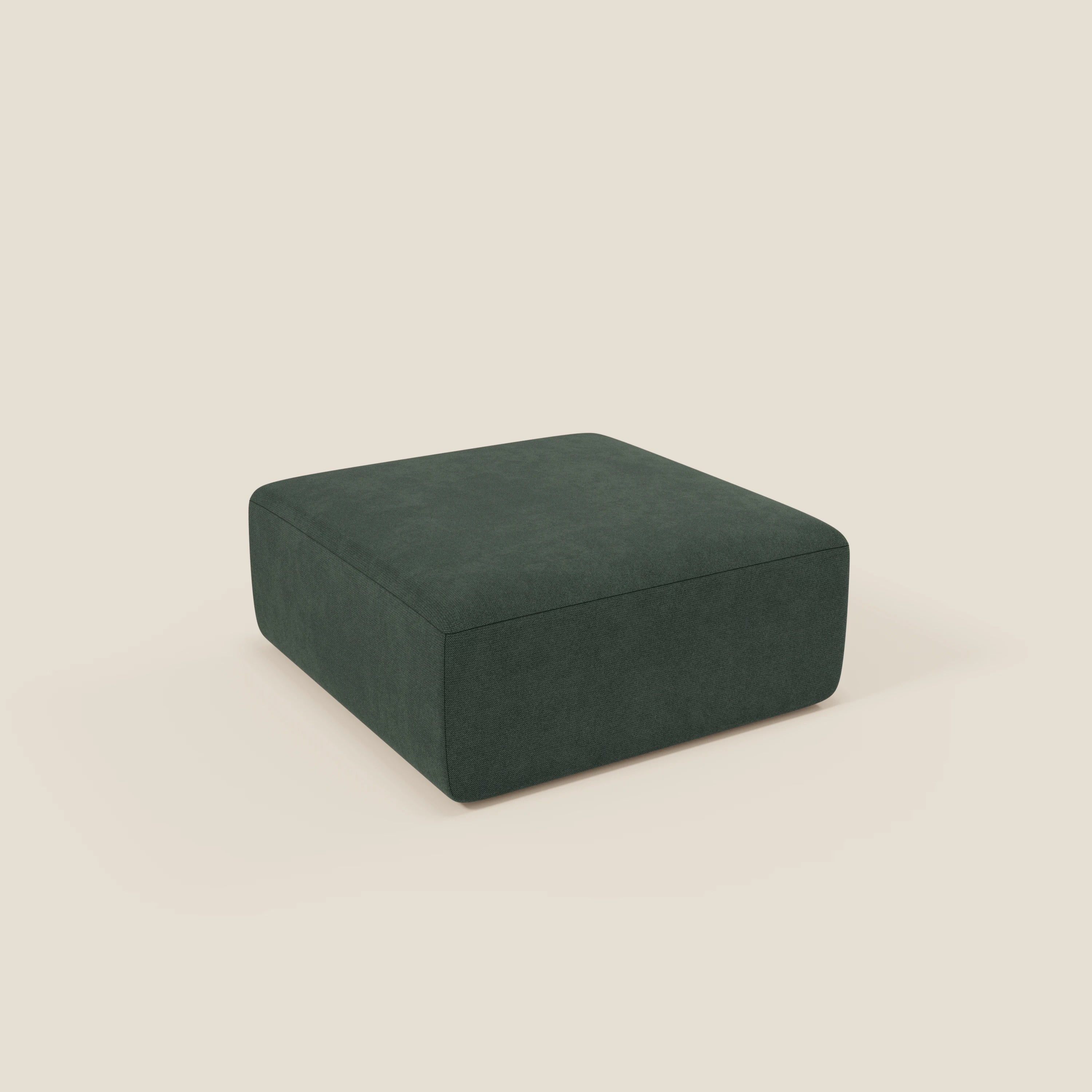 Il pouf BonBon di Divani.Store è un pouf quadrato e modulare a basso profilo in tessuto antimacchia verde T23, dal design semplice e lineare, senza gambe o ornamenti visibili, presentato su uno sfondo beige chiaro.