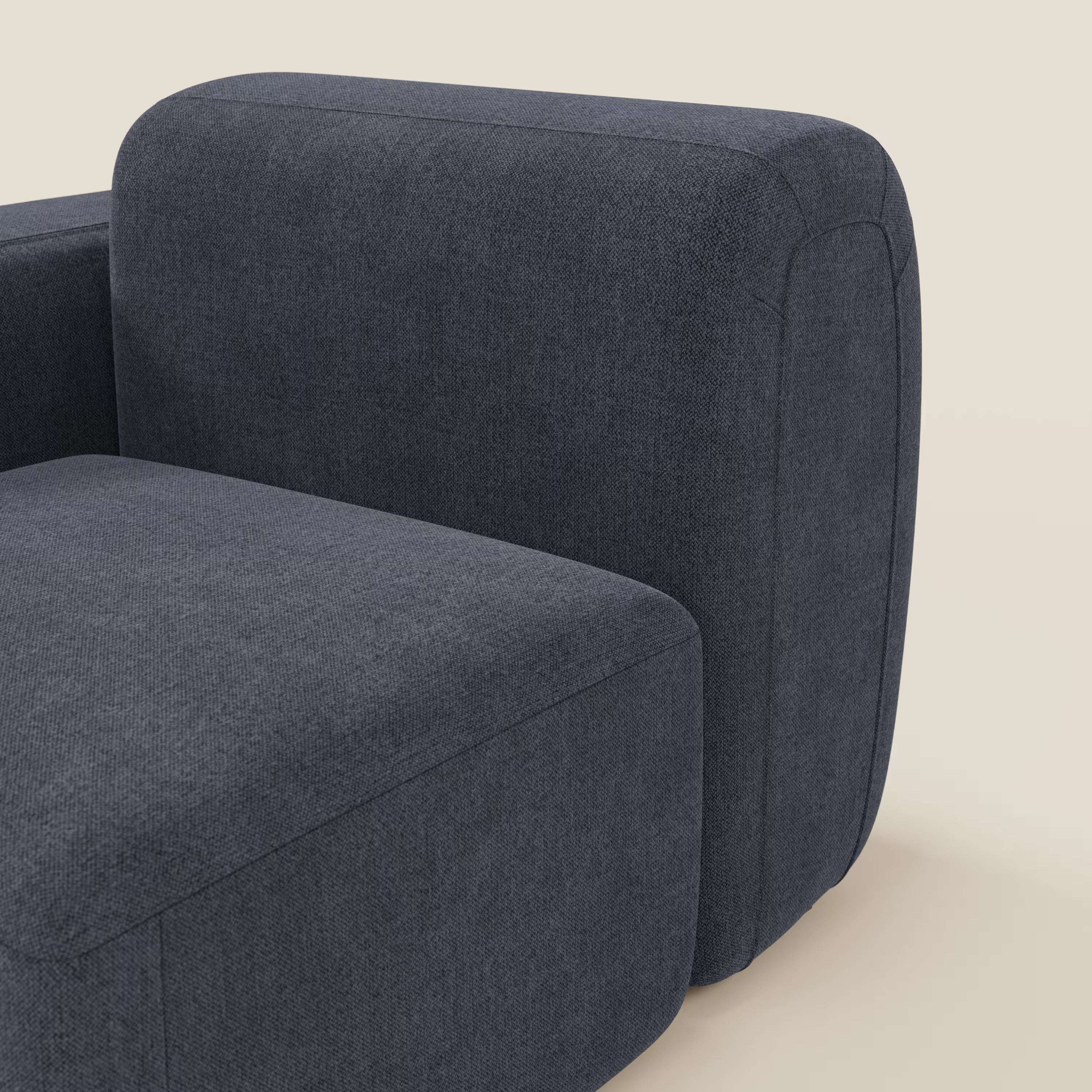 Primo piano del modulo terminale BonBon 105 cm sinistro o destro di Divani.Store in tessuto smacchiabile T23 blu ardesia, caratterizzato da ampi braccioli arrotondati e da uno spesso cuscino di seduta, che si staglia su uno sfondo beige chiaro.