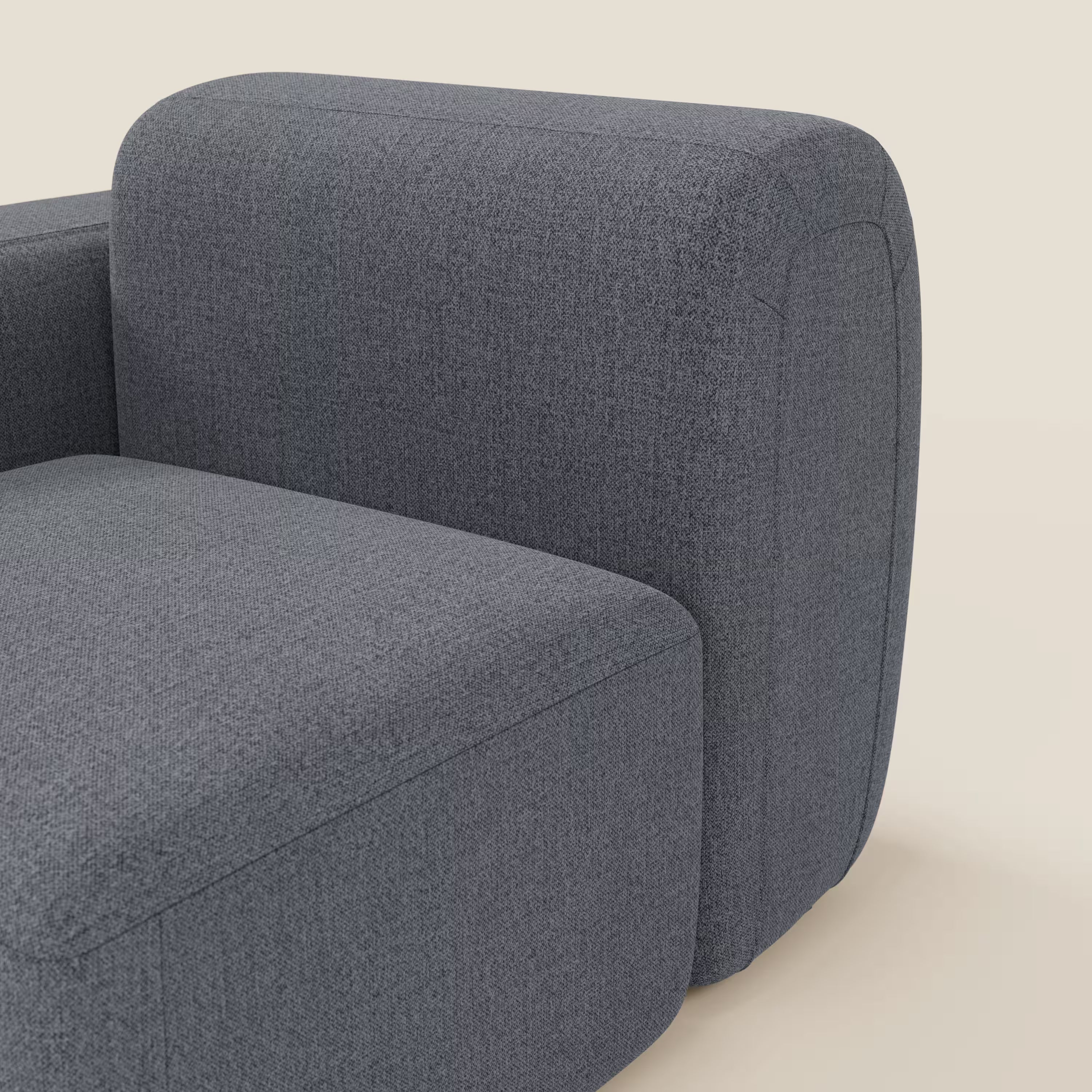 Un primo piano di BonBon modulo terminale 105 cm sinistro o destro di Divani.Store in smacchiabile T23 blu grafite mette in evidenza il cuscino di seduta arrotondato e il bracciolo con cuciture minime, su uno sfondo bianco sporco per un tocco moderno.