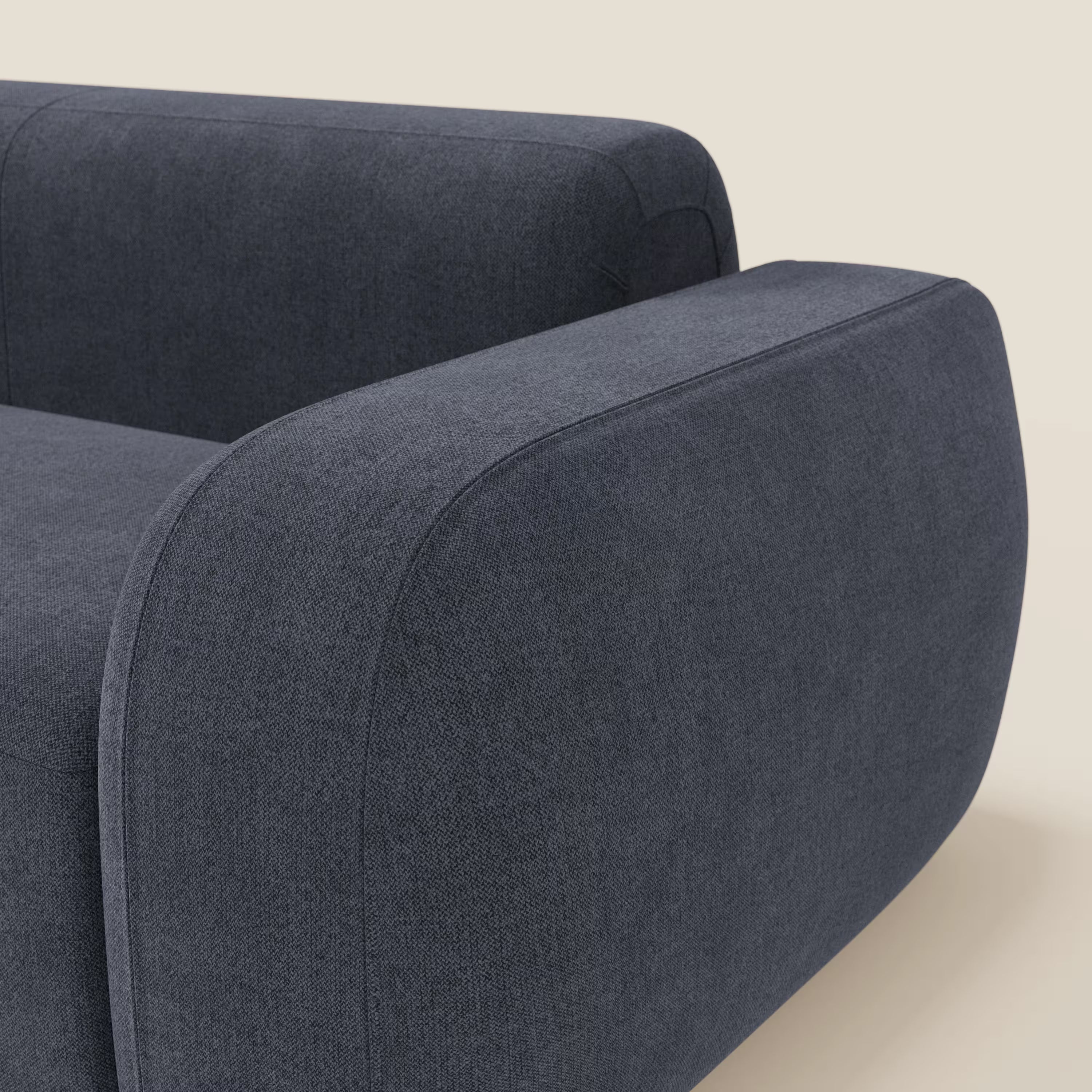 Primo piano del BonBon Divano modulare Lineare 220 di Divani.Store, caratterizzato da una seduta singola in tessuto antimacchia T23 ardesia blu. Il bracciolo e lo schienale arrotondati e ampi ne evidenziano il design moderno, su uno sfondo beige chiaro. Divano parzialmente visibile.