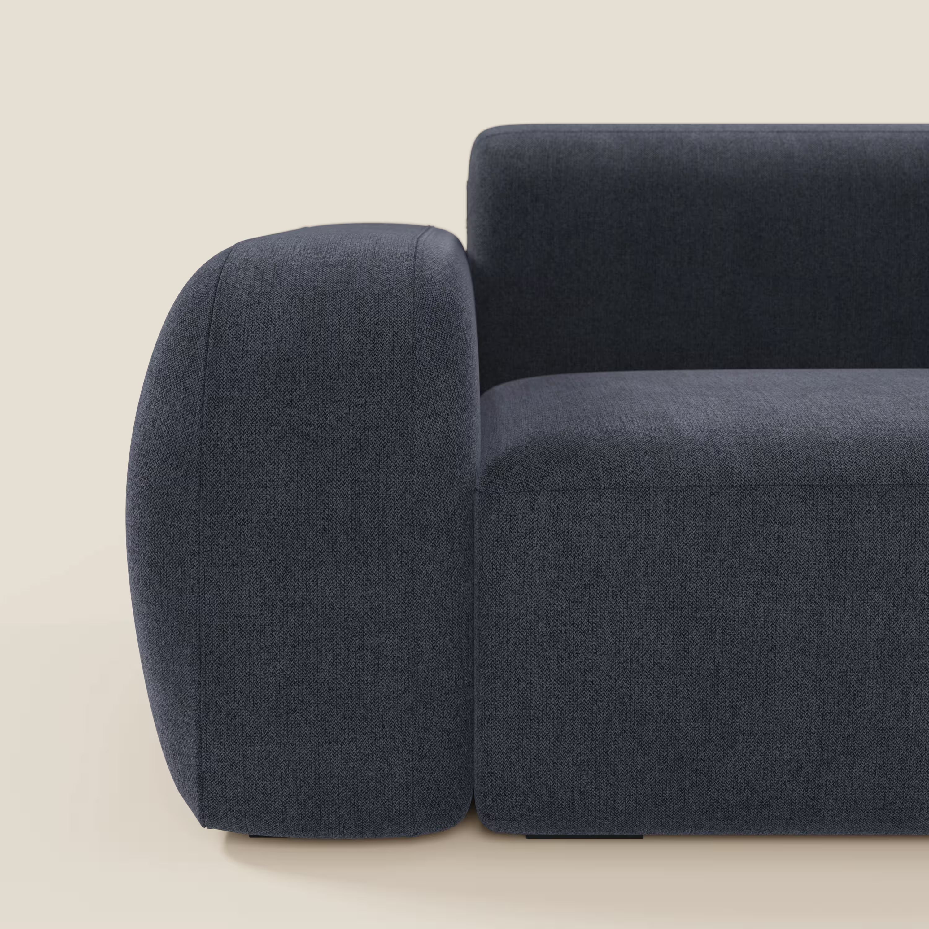 Il BonBon Divano modulare Lineare 220 di Divani.Store, in ardesia blu tessuto smacchiabile T23 con braccioli arrotondati oversize e seduta unica, spicca su uno sfondo beige in questo primo piano del suo design contemporaneo.