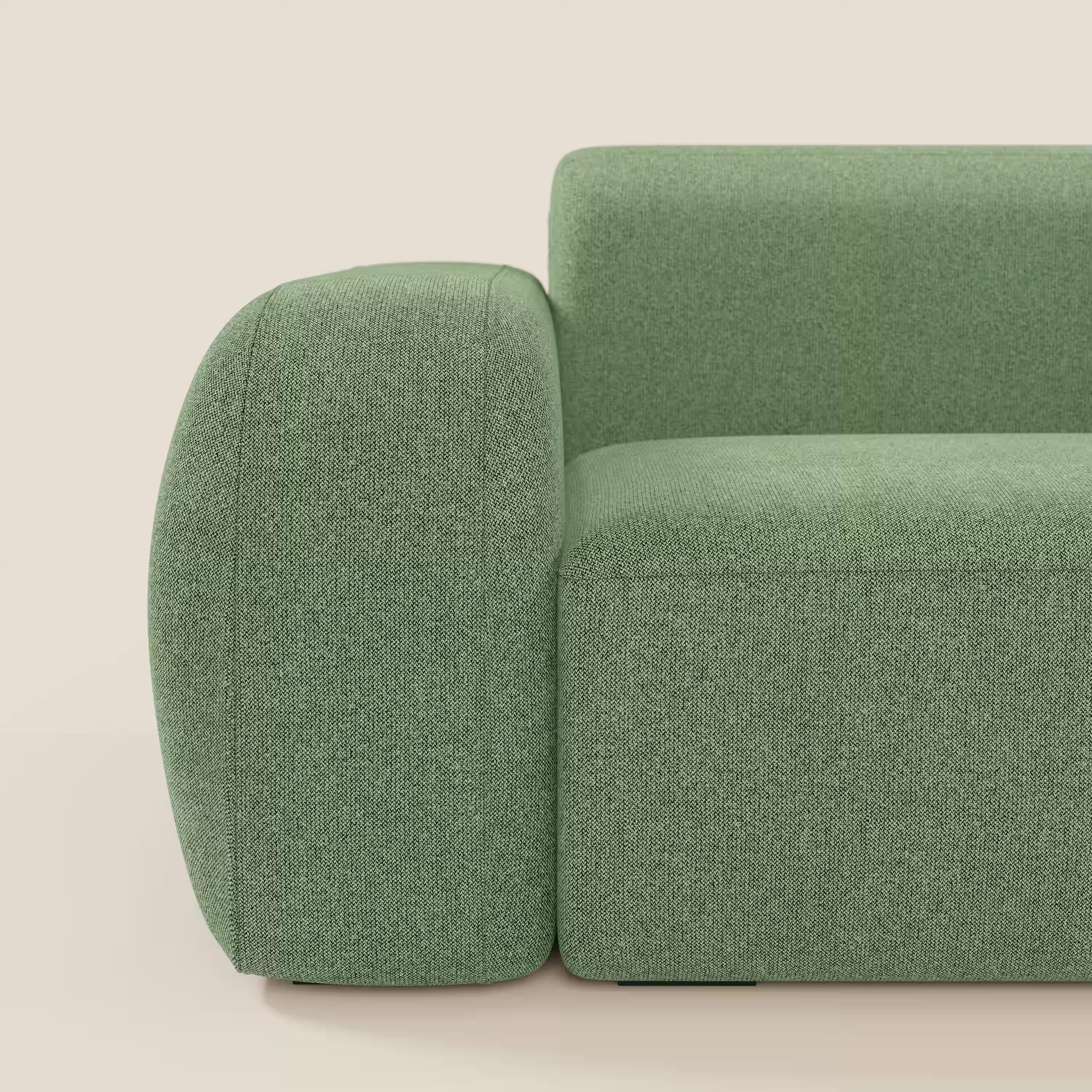 Un primo piano del BonBon Divano modulare Lineare 220 di Divani.Store mette in mostra il suo design robusto e arrotondato in tessuto menta T23 smacchiabile su uno sfondo beige tinta unita, sottolineando la morbida e moderna seduta unica.