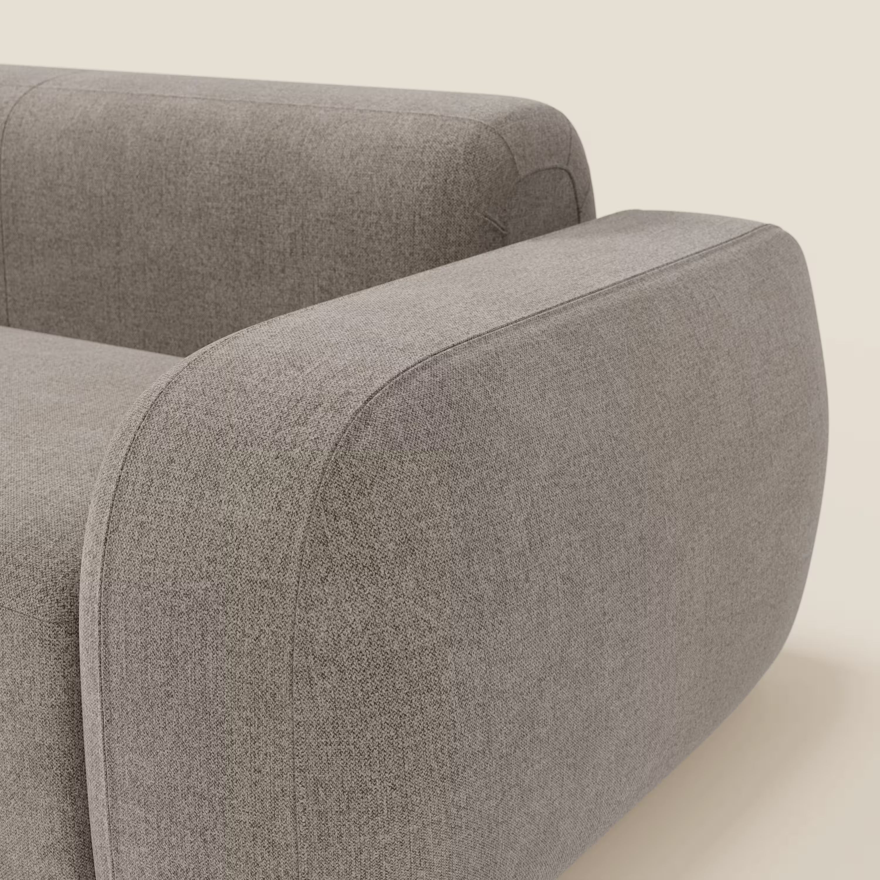 Primo piano del BonBon Divano modulare Lineare 220 di Divani.Store, caratterizzato da un design monoposto in tessuto smacchiabile T23 talpa. I braccioli ampi e arrotondati e le linee morbide conferiscono un'atmosfera morbida e contemporanea su uno sfondo bianco sporco.