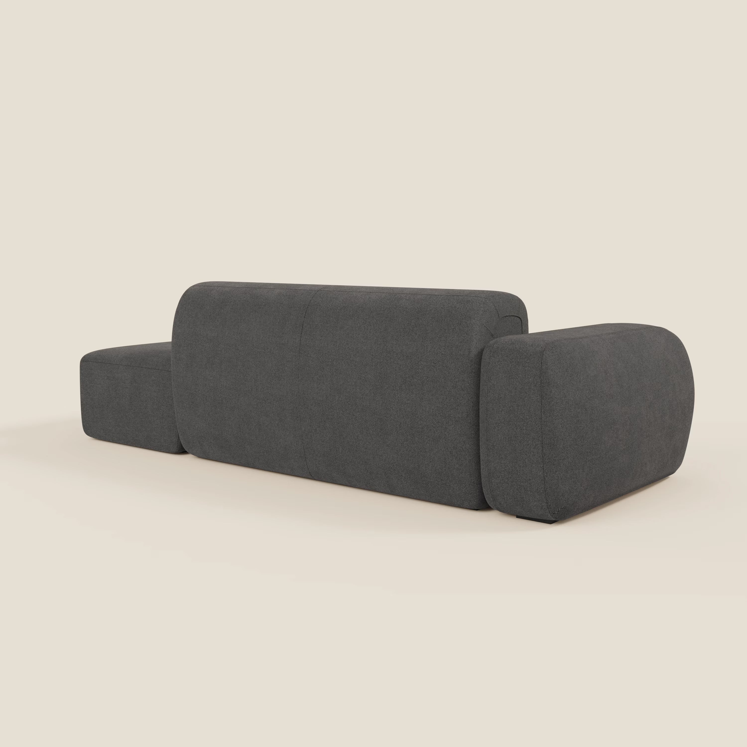 Il BonBon Divano componibile di Divani.Store in tessuto smacchiabile T23 antracite, visto da dietro, presenta braccioli arrotondati oversize, schienale basso e ampio, linee morbide e pouf terminale su fondo beige chiaro.