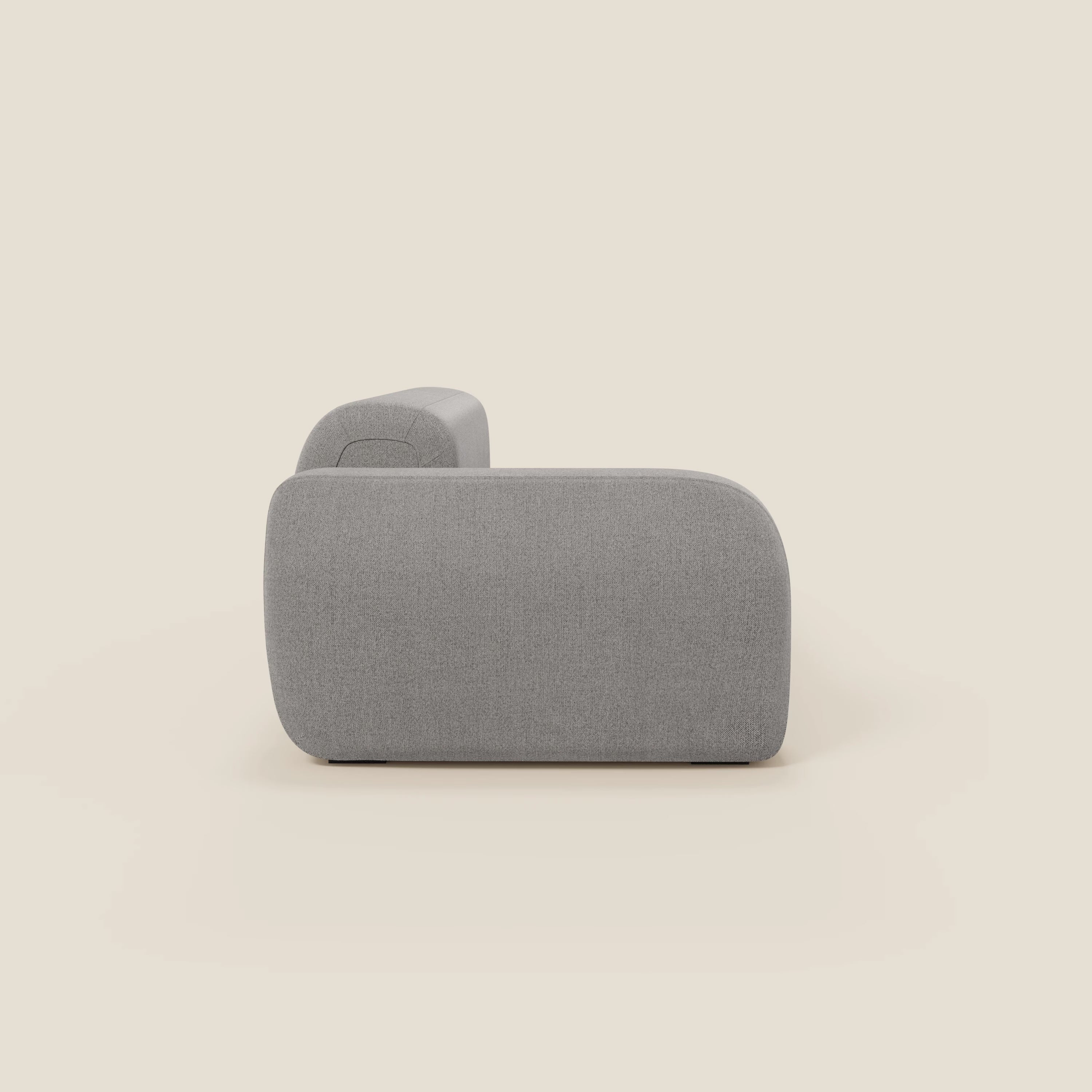 Il BonBon Divano modulare componibile di Divani.Store, in tessuto antimacchia T23 grigio chiaro con bordi arrotondati e design minimalista a basso profilo - senza gambe o decorazioni visibili - è visto di lato su uno sfondo bianco sporco.