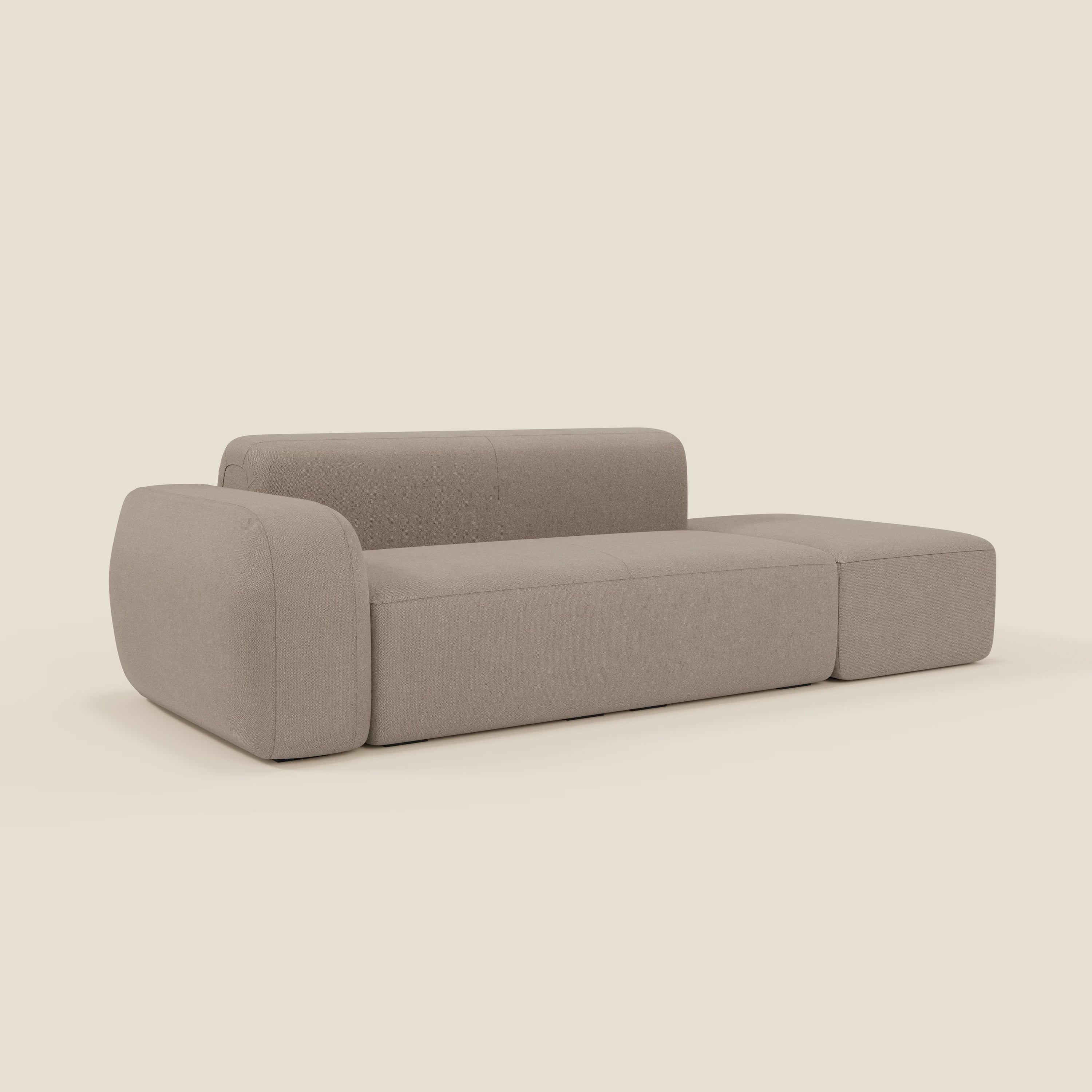 Il BonBon Divano modulare componibile di Divani.Store in smacchiabile T23 tortora ha un design marrone chiaro con bordi arrotondati, cuscini spessi, schienale basso, assenza di gambe visibili e un versatile pouf terminale per un maggiore comfort.