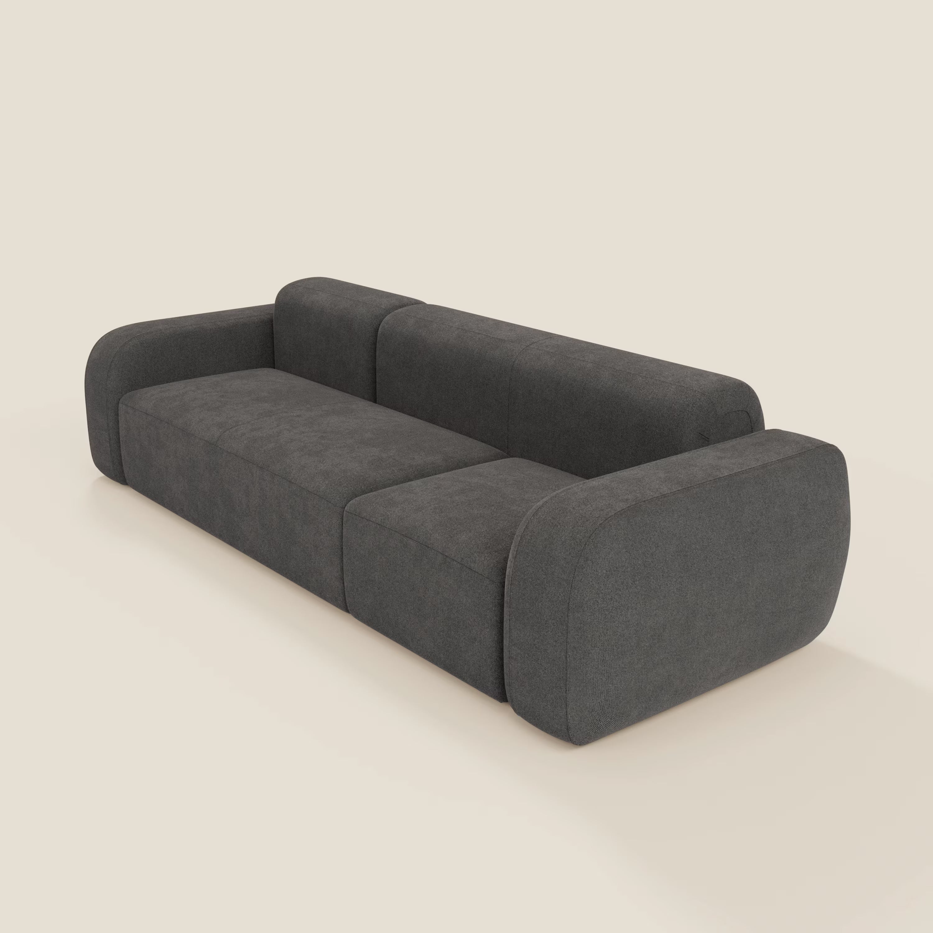 Il divano componibile BonBon Divani.Store in smacchiabile T23 antracite è caratterizzato da braccioli spessi e arrotondati, un profilo basso e squadrato e cuscini morbidi per un look minimalista e un fascino moderno unico su uno sfondo neutro.