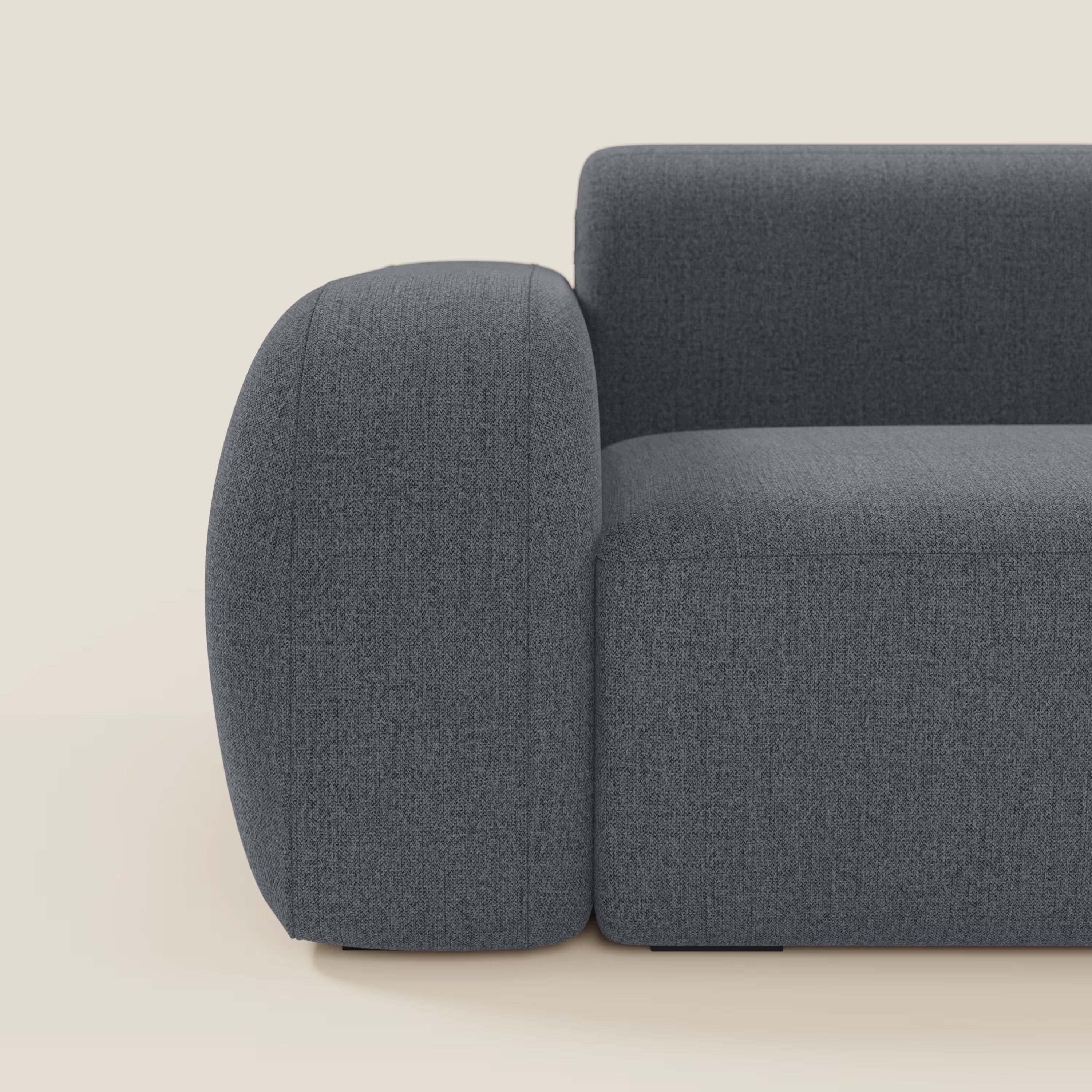 Il divano componibile BonBon - Composizione Spaccamattone di Divani.Store in tessuto antimacchia T23 blu grafite è caratterizzato da braccioli spessi e arrotondati e da una silhouette minimalista e squadrata su uno sfondo beige.