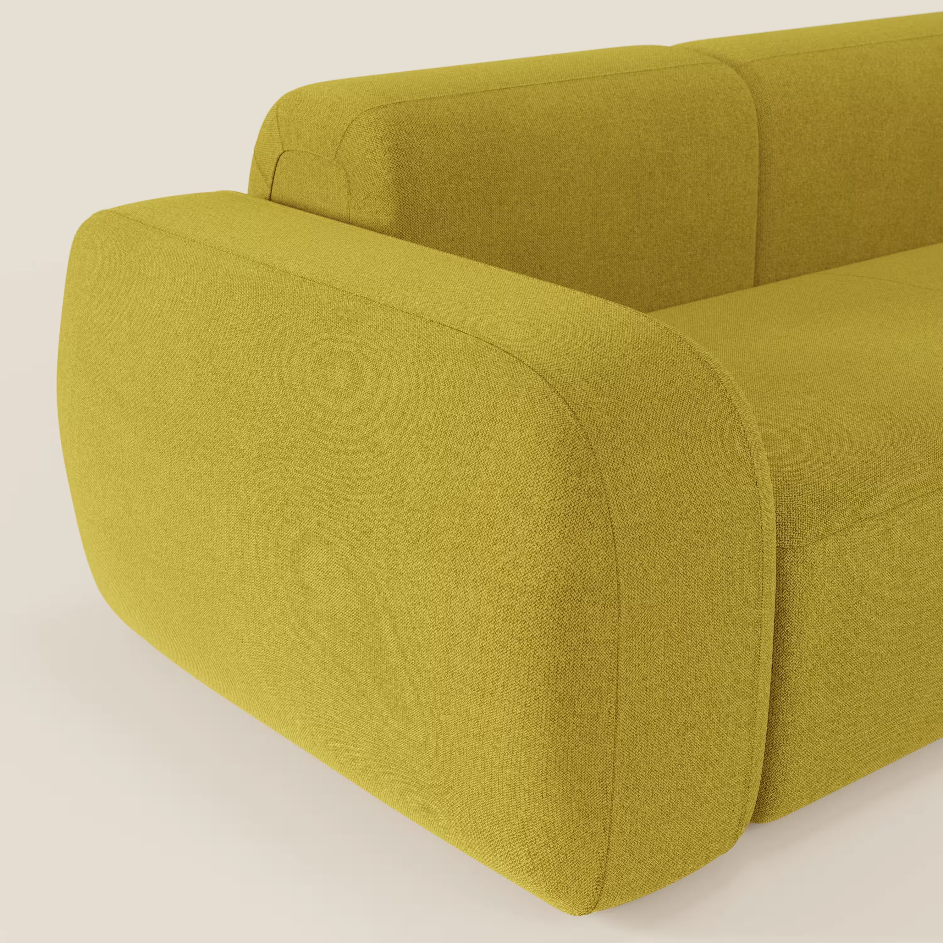 Un primo piano del BonBon Divano modulare componibile - Composizione Spaccamattone di Divani.Store in smacchiabile suola T23 giallo mostra le sue curve morbide e le cuciture minime, creando un look accogliente e moderno su uno sfondo chiaro.