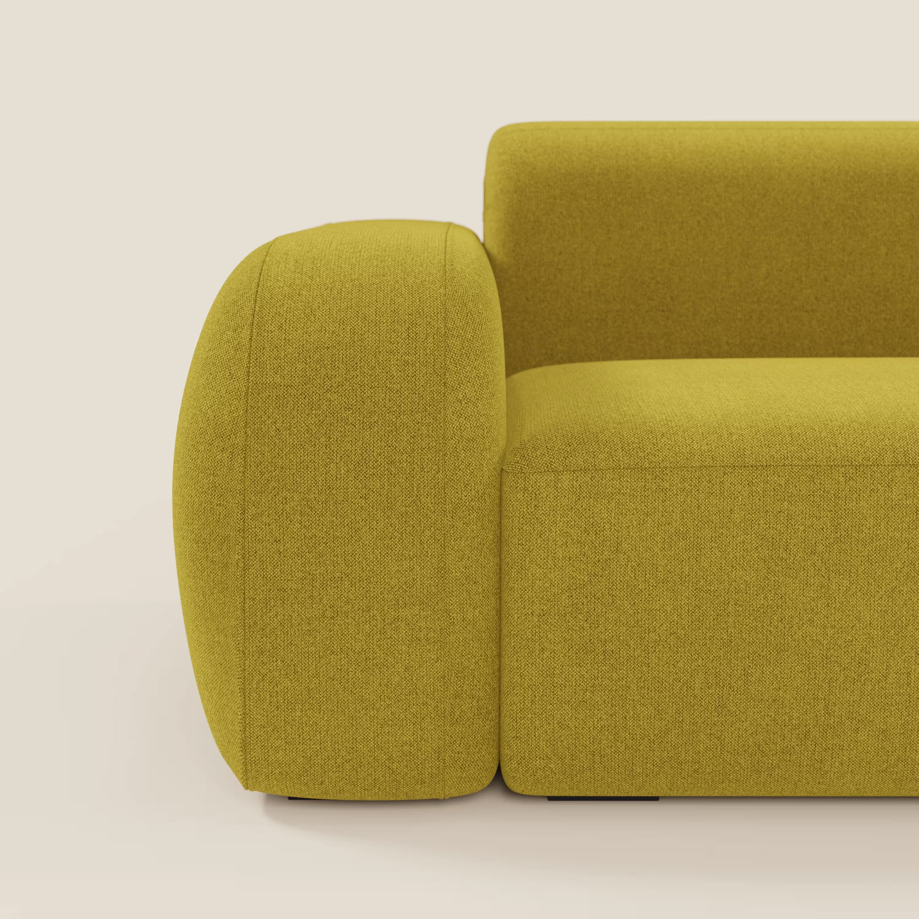 Un primo piano del divano componibile BonBon Divano - Composizione Spaccamattone in tessuto smacchiabile T23 giallo sole di Divani.Store, caratterizzato da bracciolo e schienale arrotondati, appoggiato su un pavimento neutro con sfondo crema.