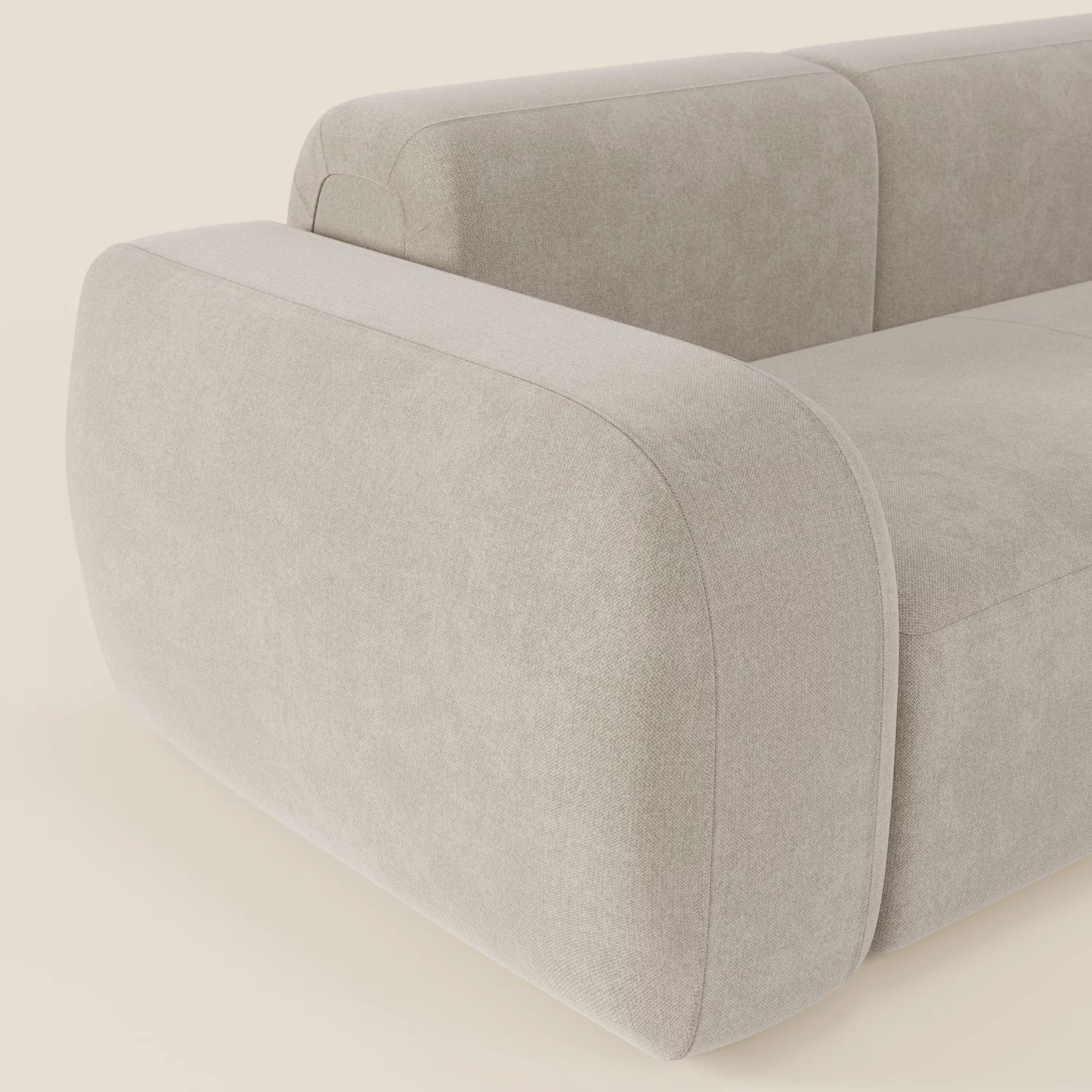 Primo piano del divano componibile BonBon - Composizione Spaccamattone di Divani.Store in tessuto panna smacchiabile T23, caratterizzato da bordi arrotondati, braccioli e schienale in tessuto felpato e un design elegante e minimalista per uno stile unico.
