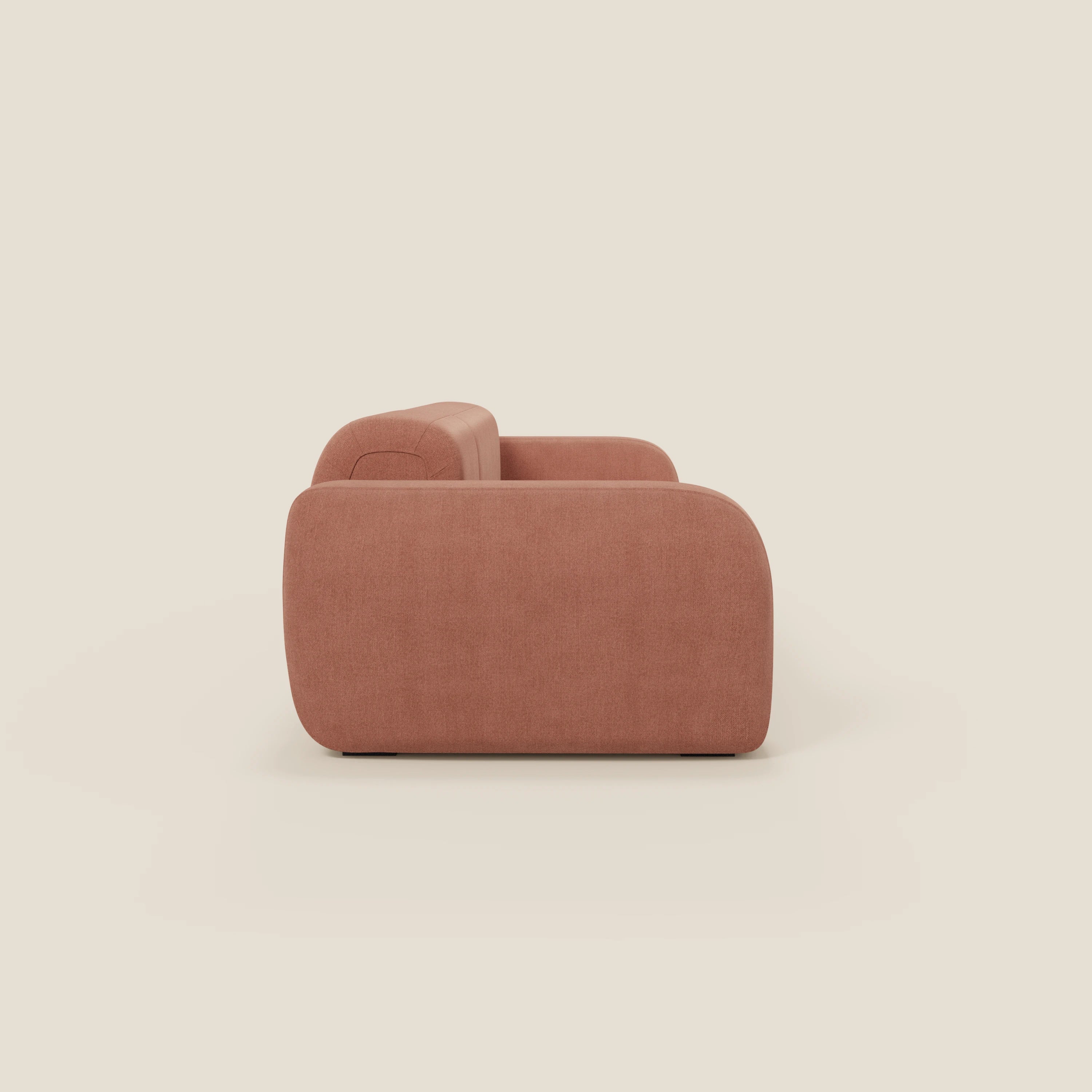 Il BonBon Divano componibile "Composizione Spaccamattone" di Divani.Store, in tessuto smacchiabile T23 pesca, è presentato lateralmente con schienale basso, bracciolo e curve arrotondate su uno sfondo bianco sporco.