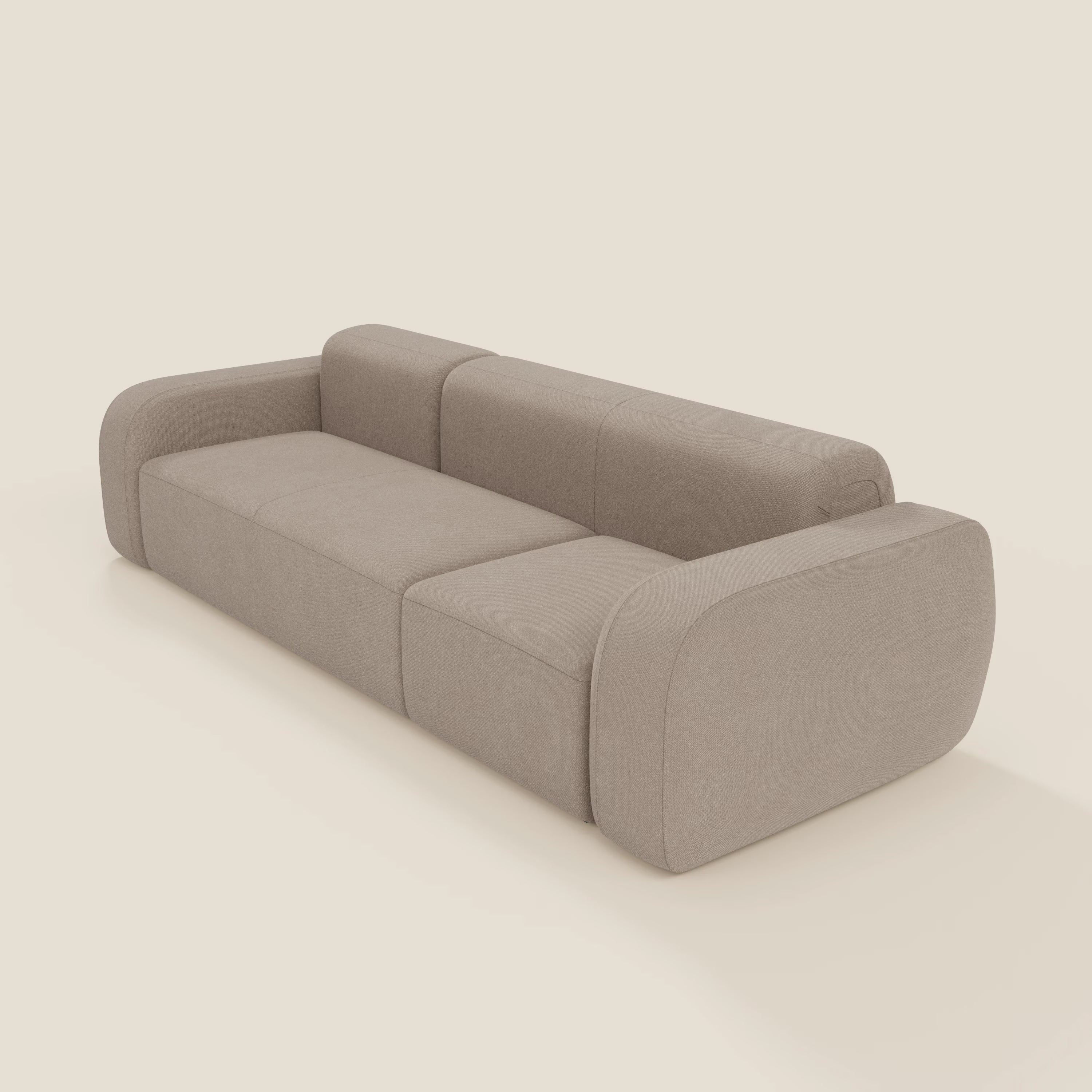 Il Divano componibile BonBon di Divani.Store è caratterizzato da un design moderno e minimalista con bordi arrotondati e tessuto T23 tortora smacchiabile, spessi braccioli e schienale imbottiti e tre sezioni di seduta su uno sfondo beige chiaro.