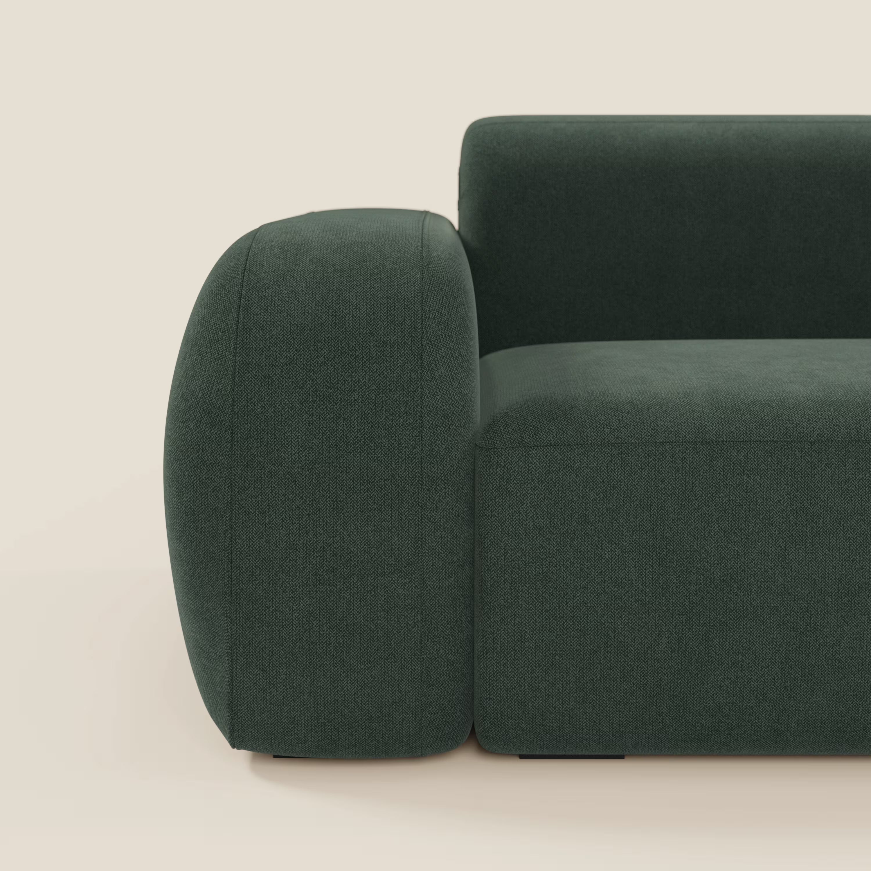 Il BonBon Divano componibile di Divani.Store in tessuto antimacchia verde T23 è caratterizzato da braccioli spessi e arrotondati e da cuscini morbidi, che mettono in mostra il suo design minimalista e contemporaneo su uno sfondo color crema.