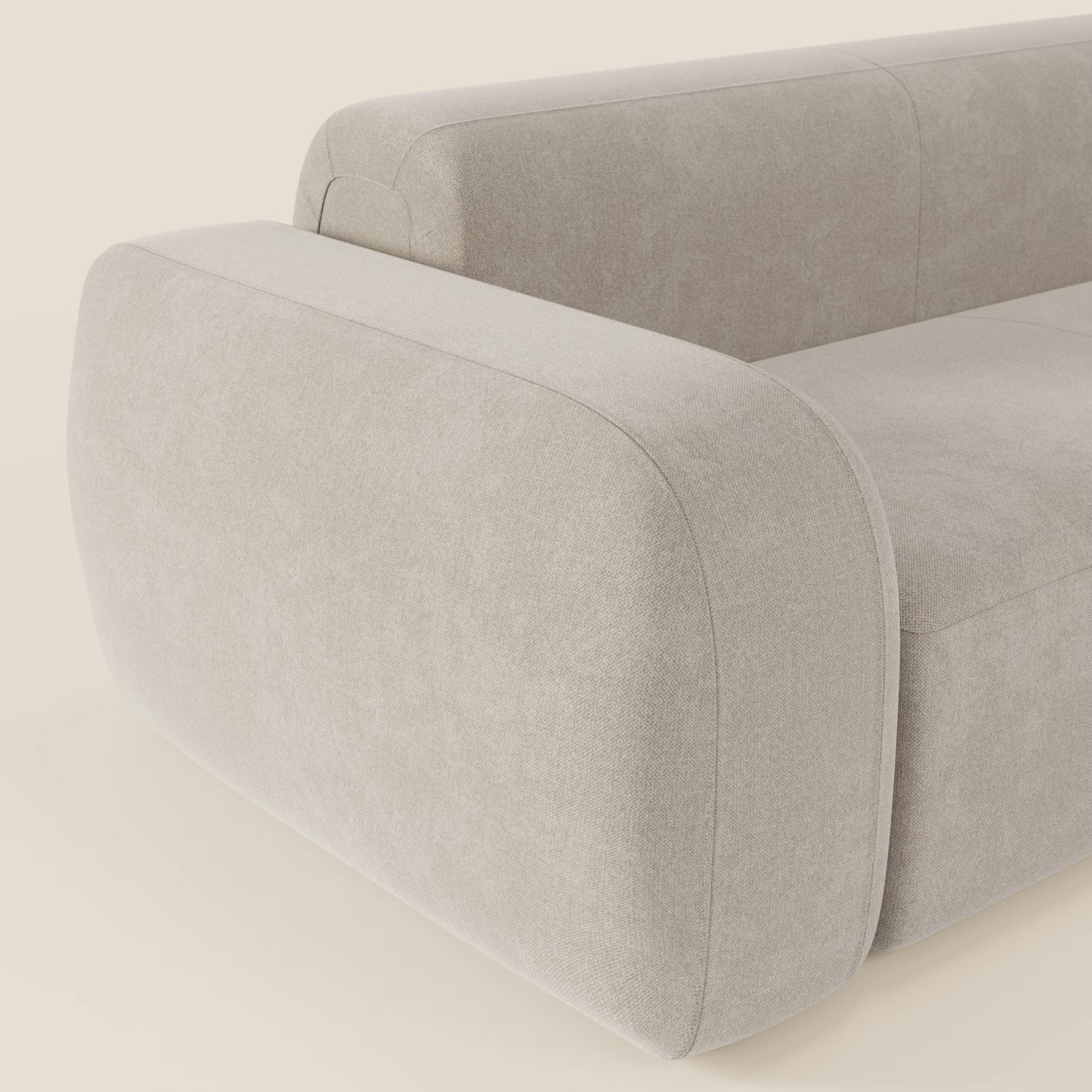 Primo piano del divano angolare componibile e modulare BonBon di Divani.Store, in tessuto smacchiabile T23 panna. I braccioli ampi e arrotondati e le linee morbide evidenziano il design italiano su una superficie color crema per un look morbido e minimalista.