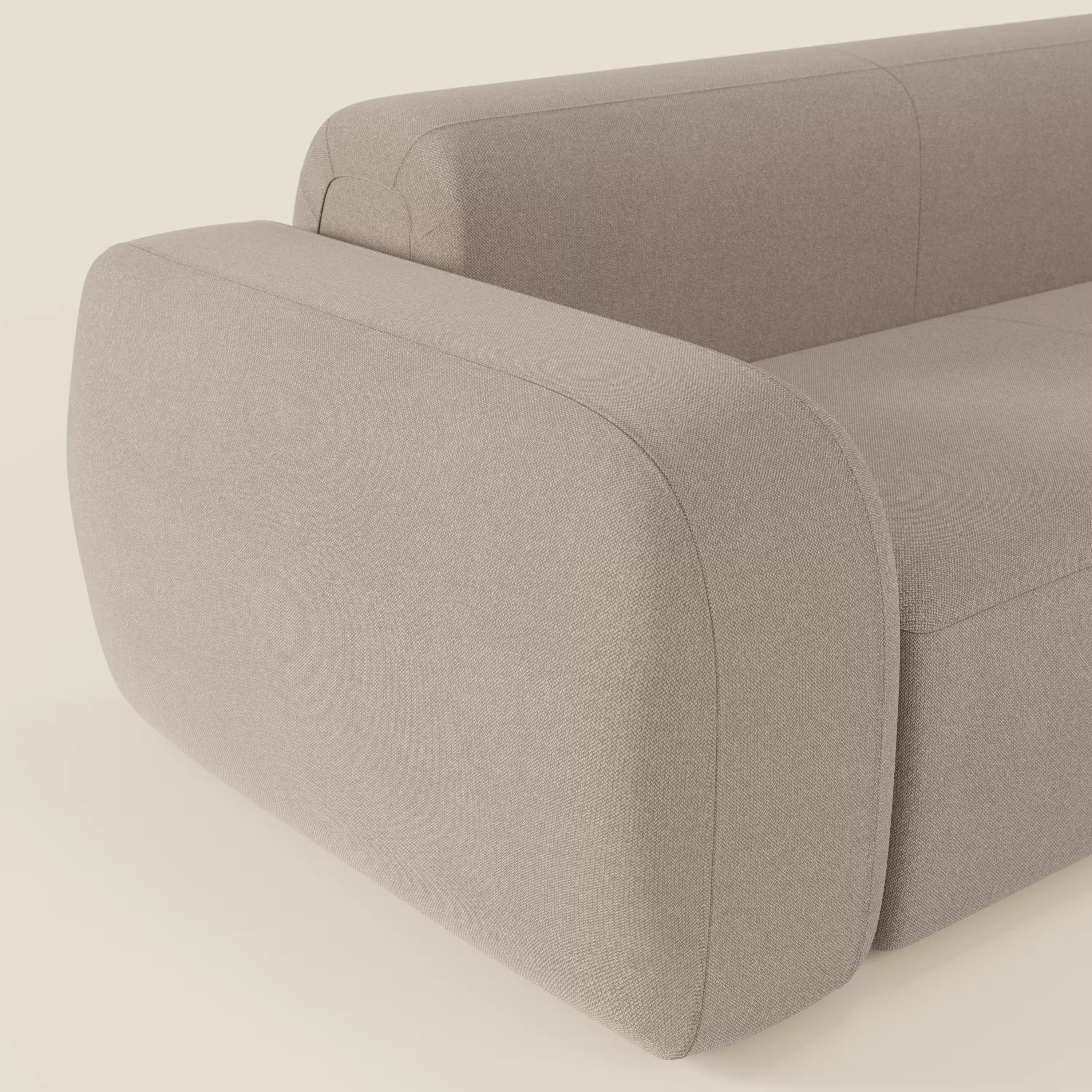Primo piano del divano angolare componibile e modulare BonBon di Divani.Store, caratterizzato da tessuto smacchiabile T23 tortora, bordi arrotondati, braccioli ampi e morbidi e un design minimale e contemporaneo su uno sfondo neutro.