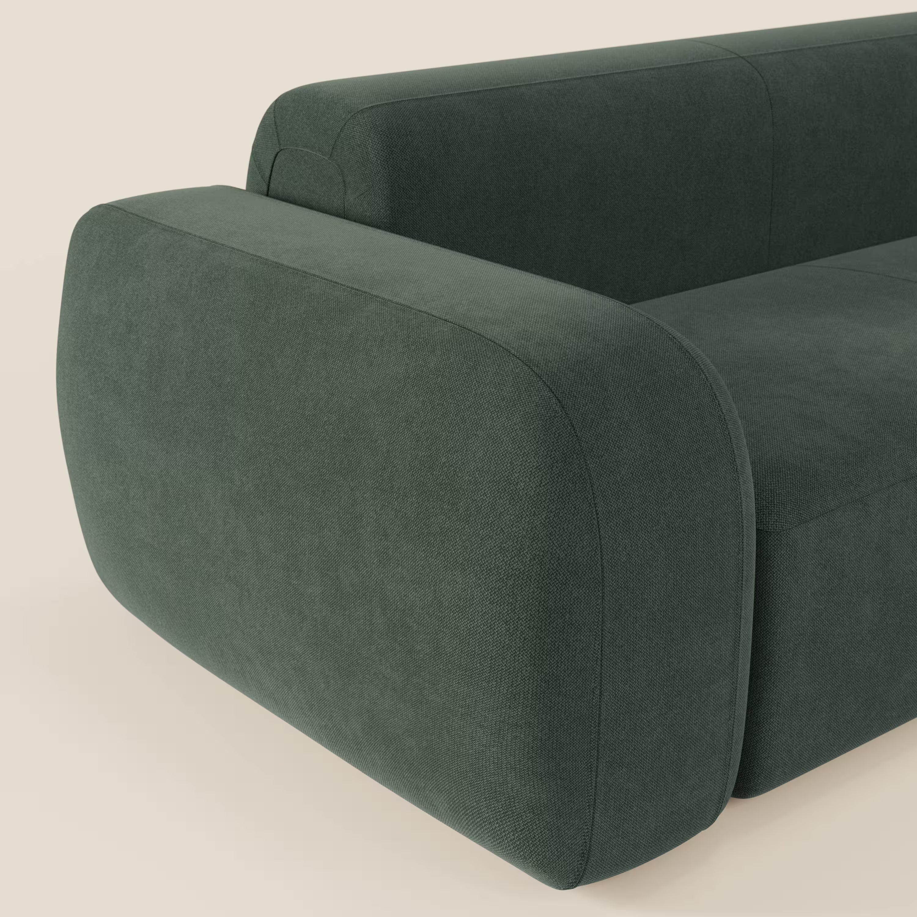 Un primo piano del divano angolare componibile e modulare BonBon di Divani.Store, rivestito in tessuto smacchiabile T23 verde, caratterizzato da bordi lisci e arrotondati e da un bracciolo imbottito che ne sottolineano il design minimalista e contemporaneo.