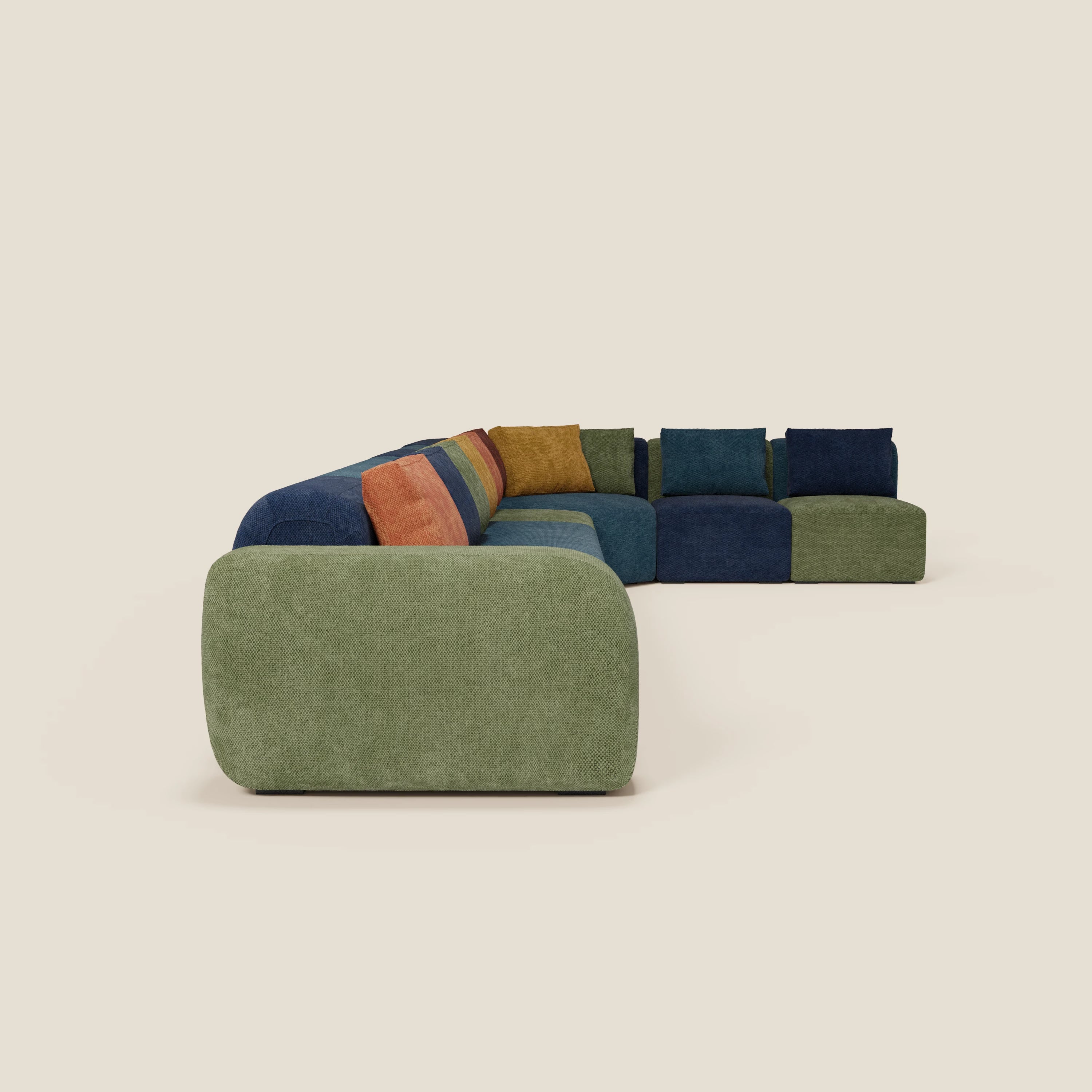 BonBon Grande Fratello Edition di Divani.Store è un divano modulare a L con cuscini in tessuto verde, blu navy, arancione bruciato e giallo senape, su sfondo beige chiaro.