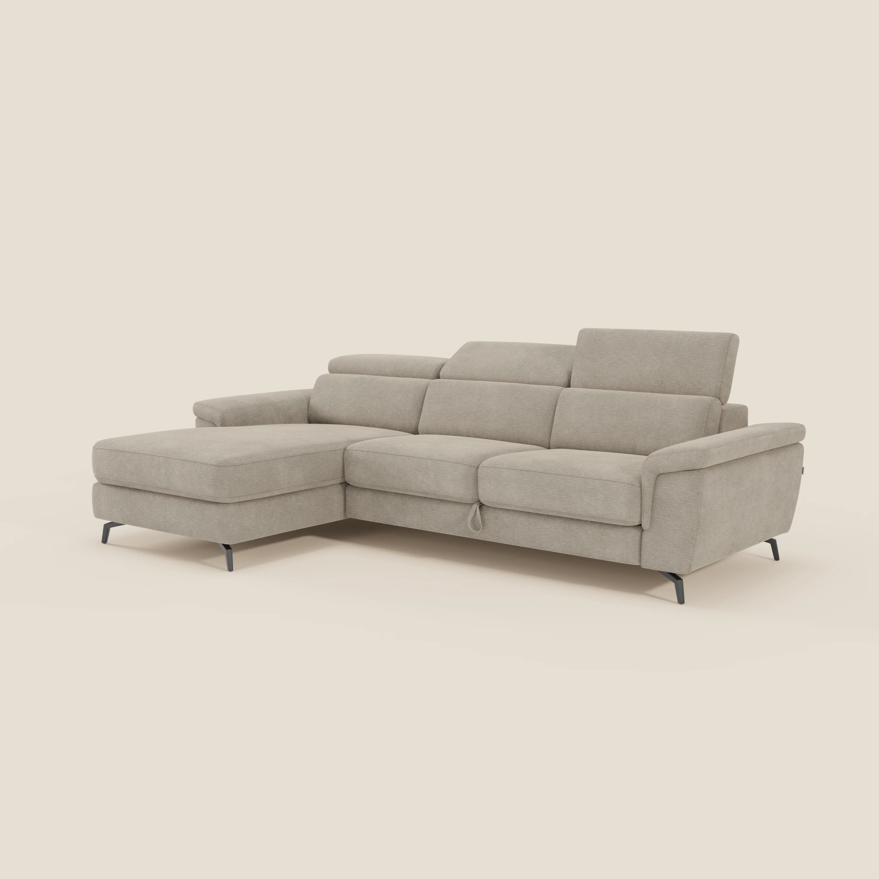 Il divano Estro estraibile di Divani.Store in impermeabile T14 beige è caratterizzato da una chaise longue sinistra, poggiatesta regolabili, linee eleganti e gambe sottili in metallo nero. Questo divano moderno è in grado di ospitare 3-4 persone, su uno sfondo color crema.