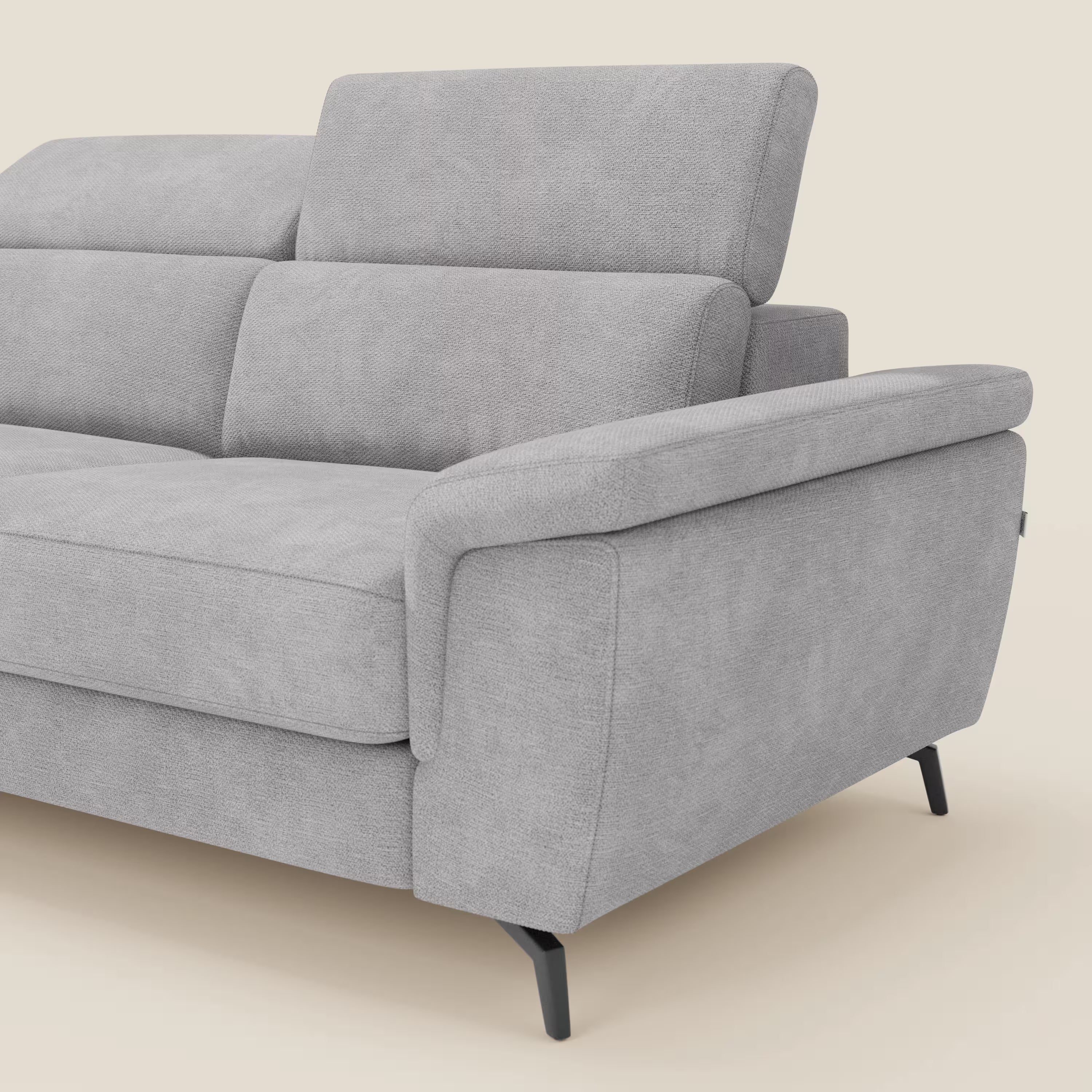 Il divano Estro estraibile di Divani.Store è dotato di chaise-longue, poggiatesta reclinabili e tessuto impermeabile T14 grigio chiaro. Le eleganti gambe in metallo nero completano il look moderno. Solo una parte del divano è raffigurata su uno sfondo bianco sporco.