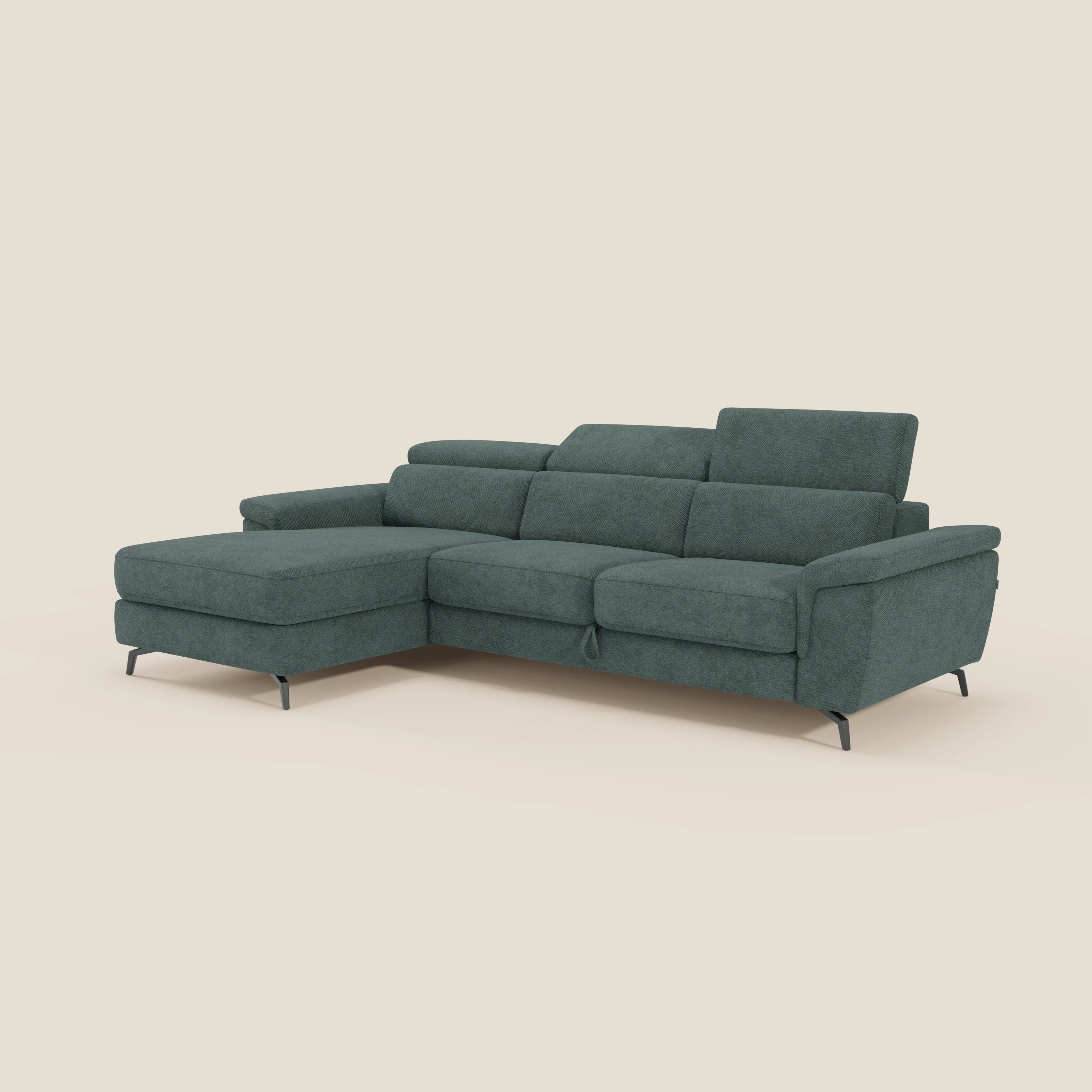 Estro Divano estraibile di Divani.Store è un divano a L in tessuto impermeabile verde T14 con poggiatesta reclinabili, chaise-longue a sinistra, schienali bassi e sottili gambe in metallo nero, su sfondo beige.