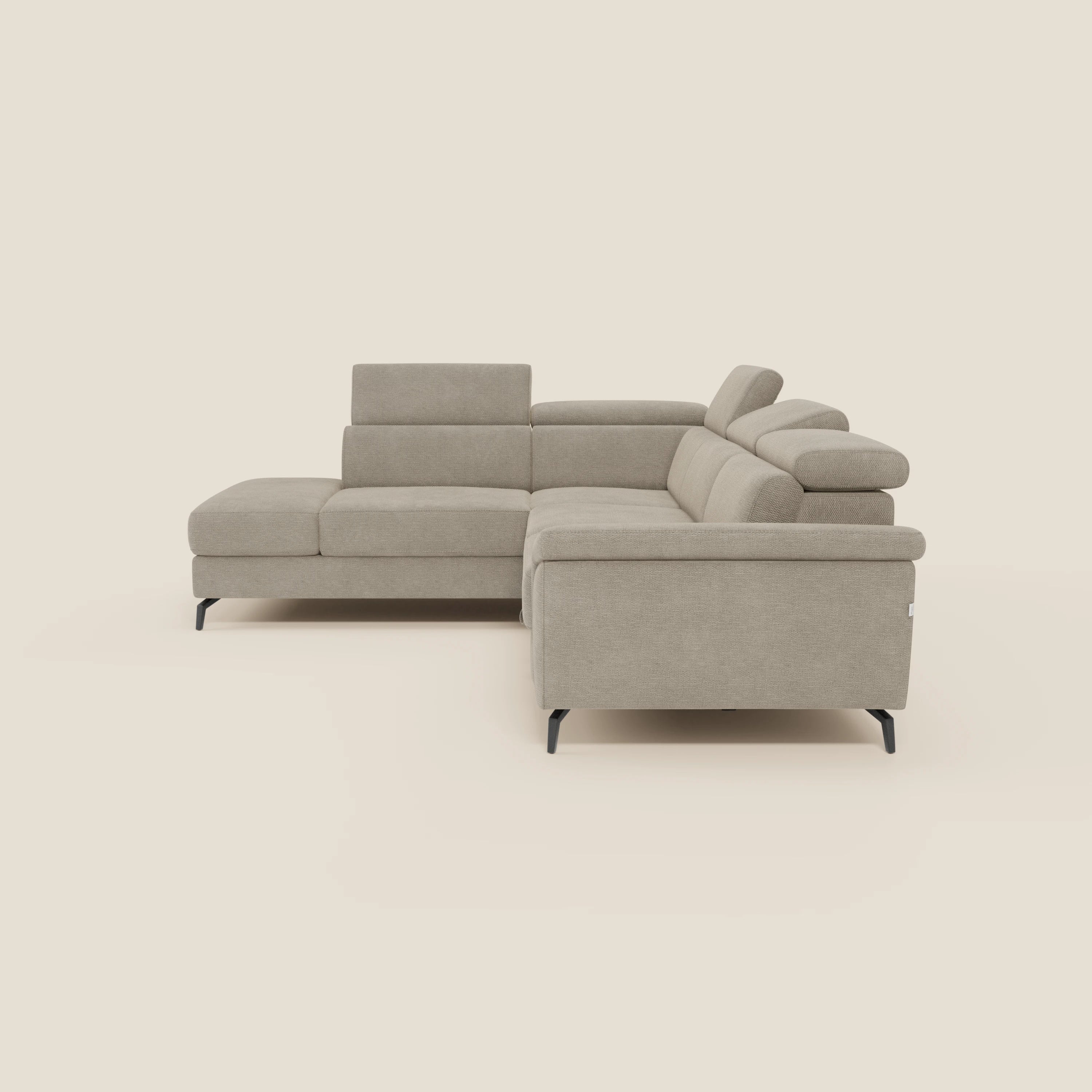 Estro Divano angolare estraibile di Divani.Store è caratterizzato da poggiatesta regolabili, tessuto impermeabile beige T14, braccioli bassi e gambe sottili in metallo nero. Le linee pulite e minimaliste e i cuscini morbidi offrono comfort su uno sfondo color crema.