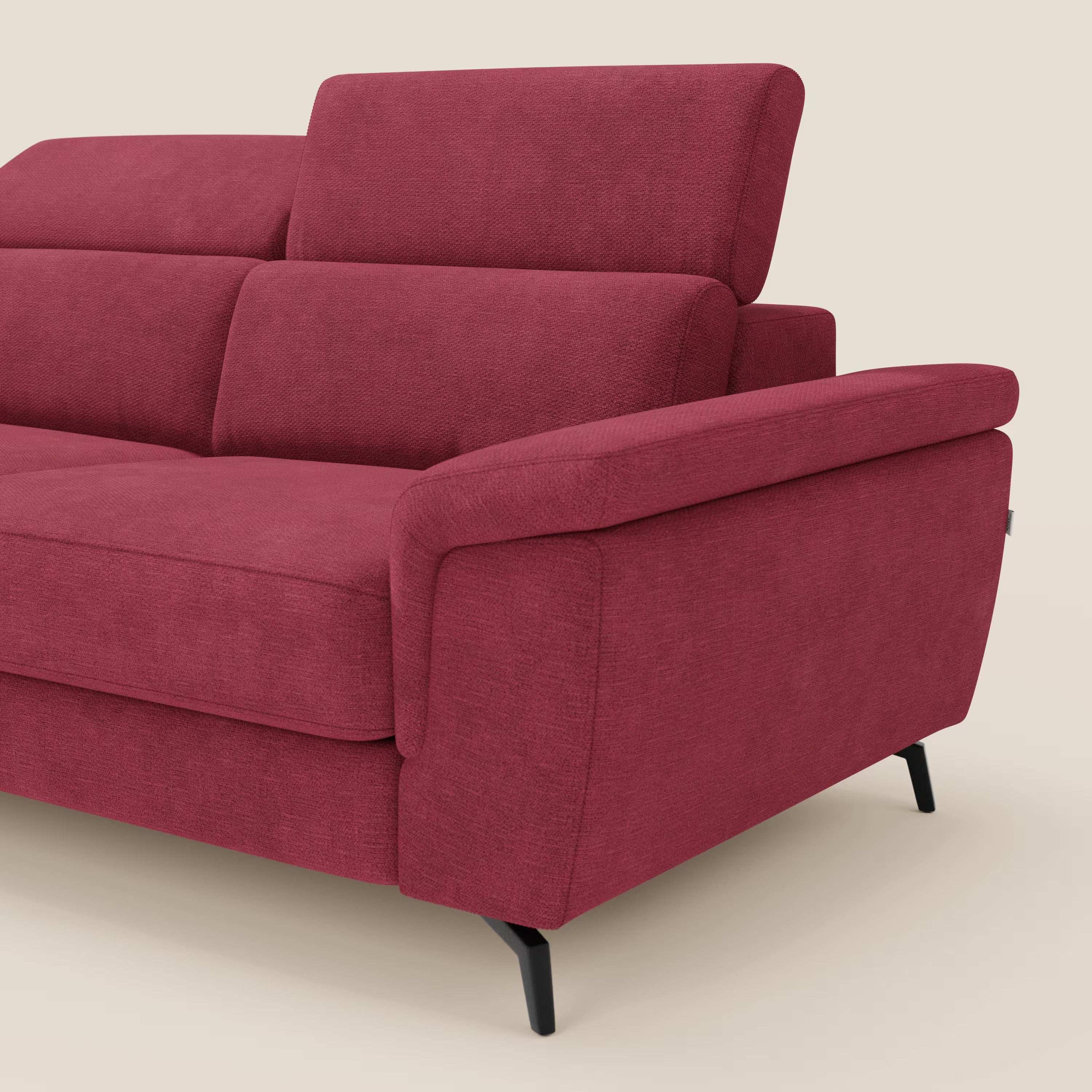 L'Estro Divano 3 posti con pouf estraibile di Divani.Store, in tessuto impermeabile T14 rosso con poggiatesta reclinabili e ampio bracciolo, appare su uno sfondo beige chiaro. È visibile solo un braccio con parte della seduta, dello schienale e del poggiatesta.