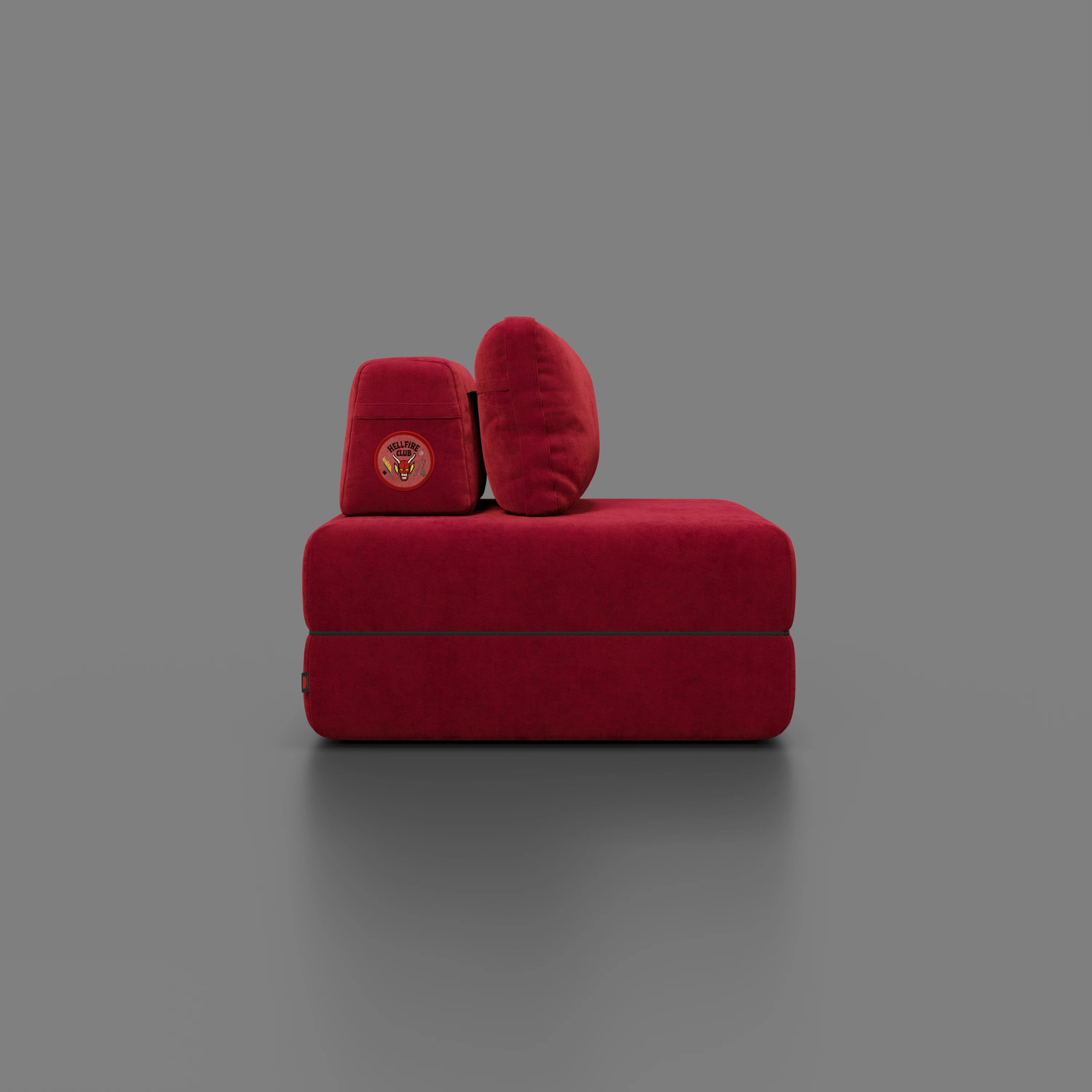 Divani.Store Rift poltrona letto STRANGER THINGS Edition, moderna e squadrata, è caratterizzata da un tessuto rosso intenso e antimacchia, da un materasso in memory foam alto 22 cm e da linee minimaliste su uno sfondo grigio semplice per un look contemporaneo.