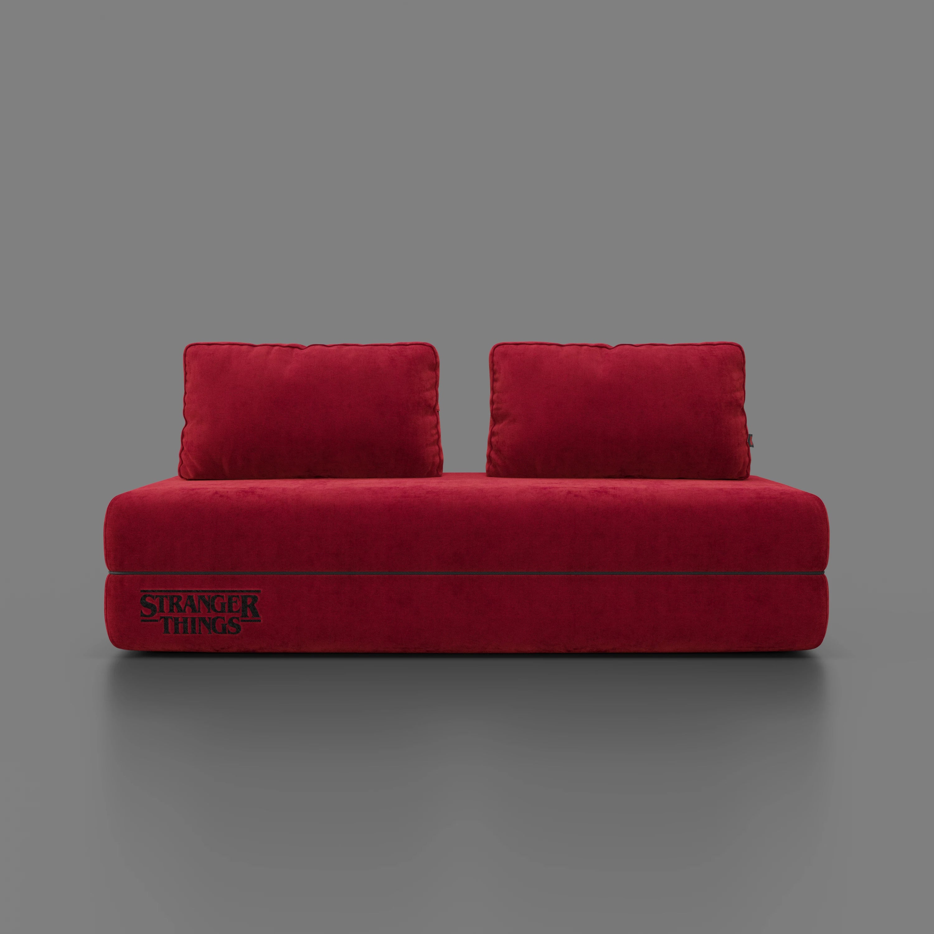 Il divano letto matrimoniale Rift STRANGER THINGS Edition di Divani.Store, in tessuto rosso antimacchia con schienali mobili e materasso in memory foam da 22 cm, presenta il logo "Stranger Things" per un tocco audace ispirato a Netflix.